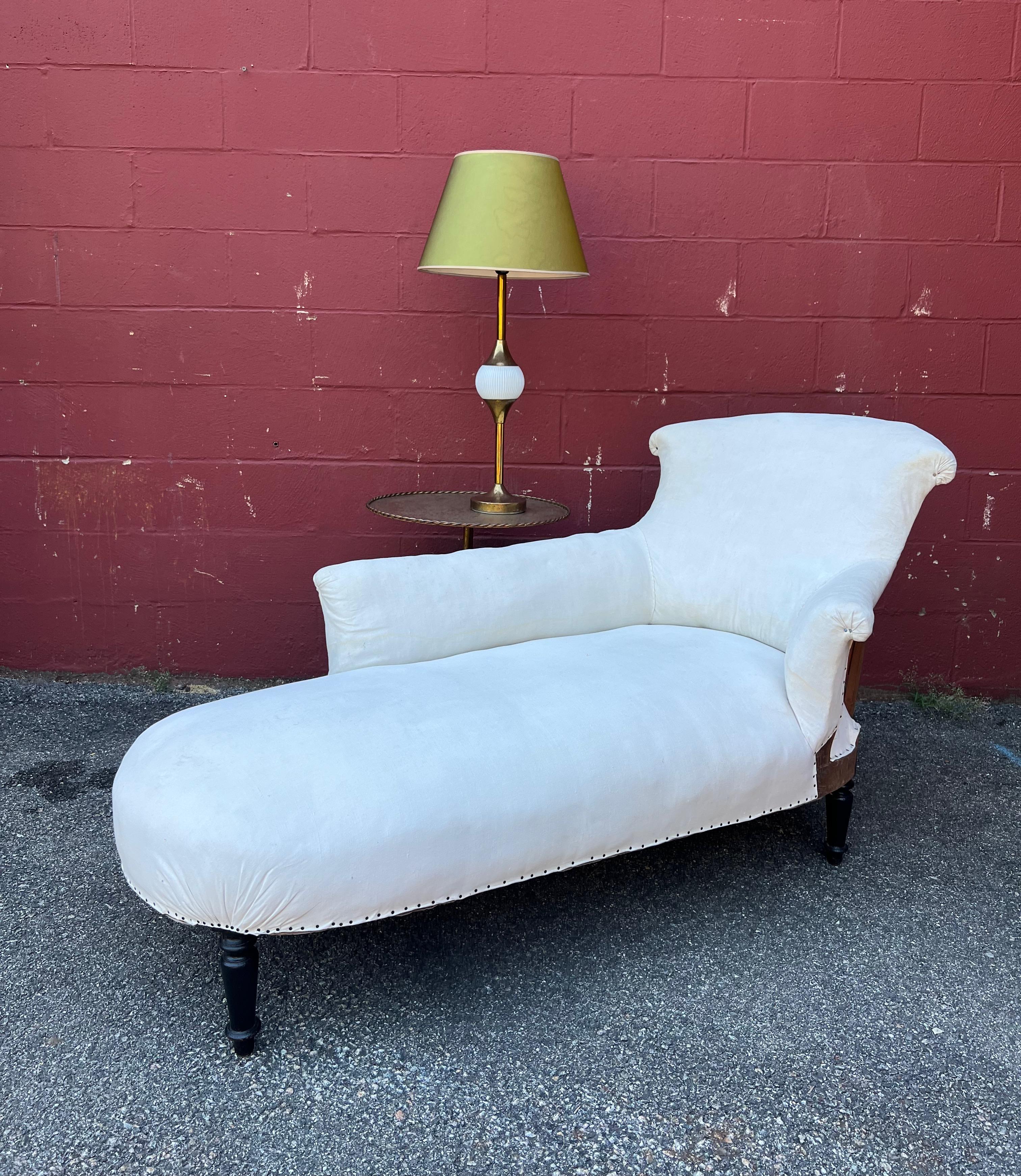 An exquisite French 19th century Napoleon III asymmetrical chaise lounge. This timeless classic is perfect for adding a touch of elegance and effortless style to any space. The classic French design features a charming “chapeau de Gendarme” detail