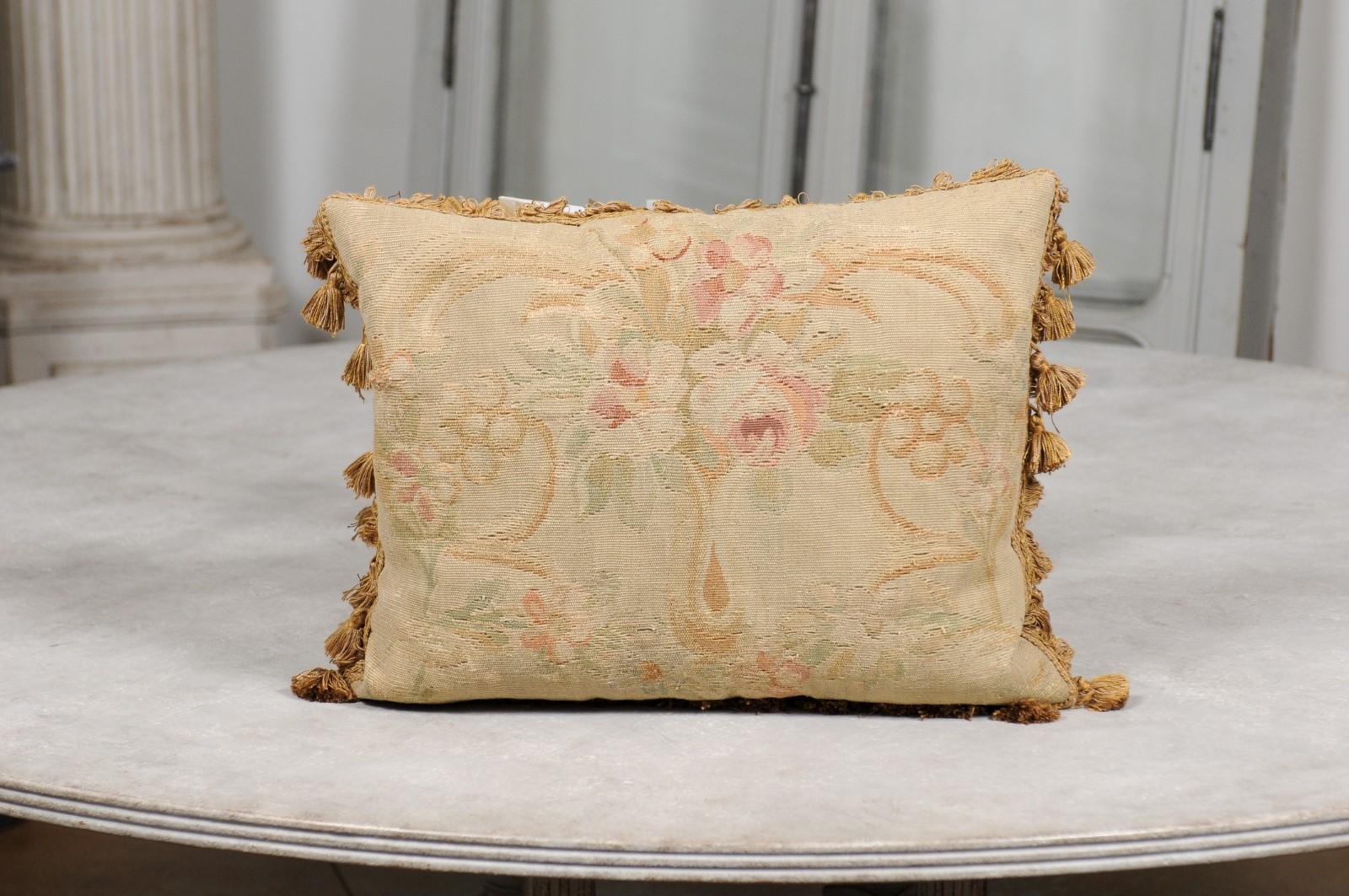 A French Aubusson tapestry pillow from the 19th century, with bouquet of flowers and tassels. Woven during the 19th century in the Aubusson tapestry manufacture located in central France, this horizontal pillow features a central bouquet of pink and