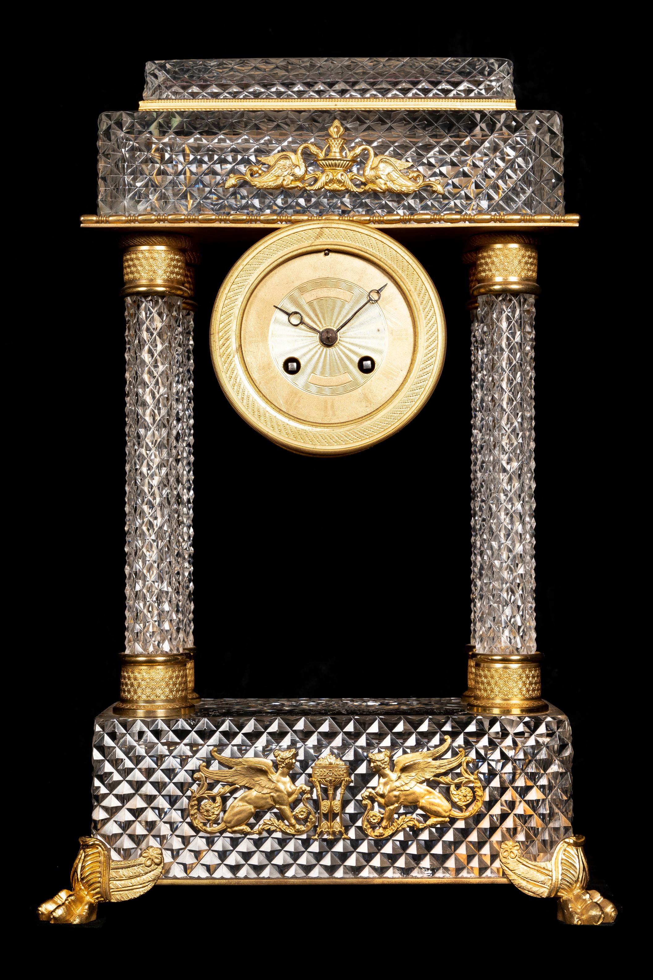 An exquisite and finely crafted Large 19th century Baccarat crystal and ormolu French Empire style Neoclassical mantel clock. This elegant timepiece features a striking architectural form centered by a circular movement drum with a delicately