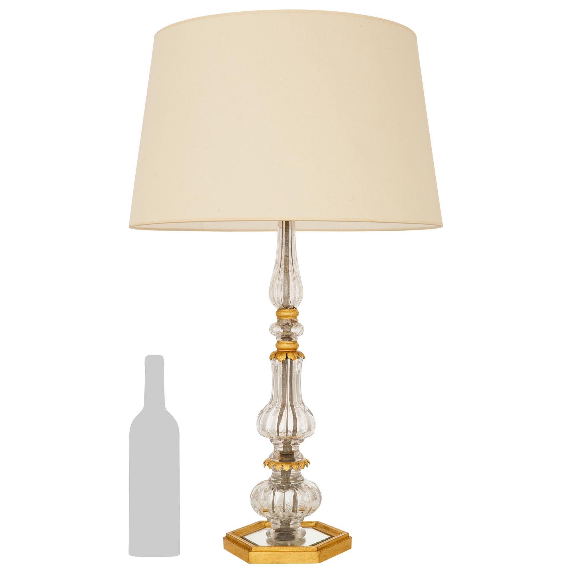 Una preciosa y muy decorativa lámpara francesa del siglo XIX de cristal de Baccarat, metal dorado y madera dorada. Esta impresionante lámpara se eleva sobre una base hexagonal de madera dorada con bordes moteados, mientras que lleva una placa de