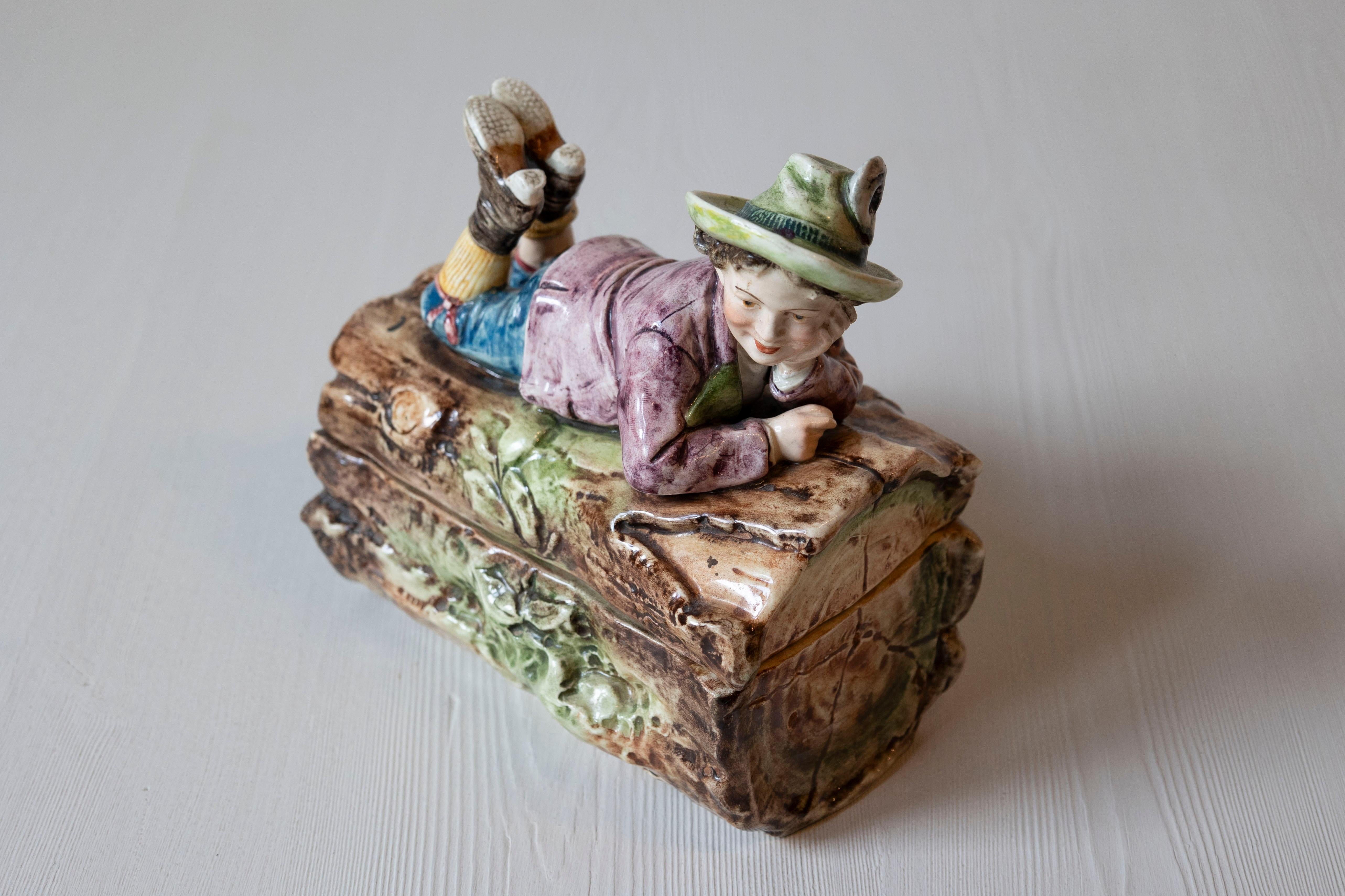 Ceramic French 19th Century Barbotine Bonbon Box Depicting a Boy Laying on a Tree Trunk For Sale