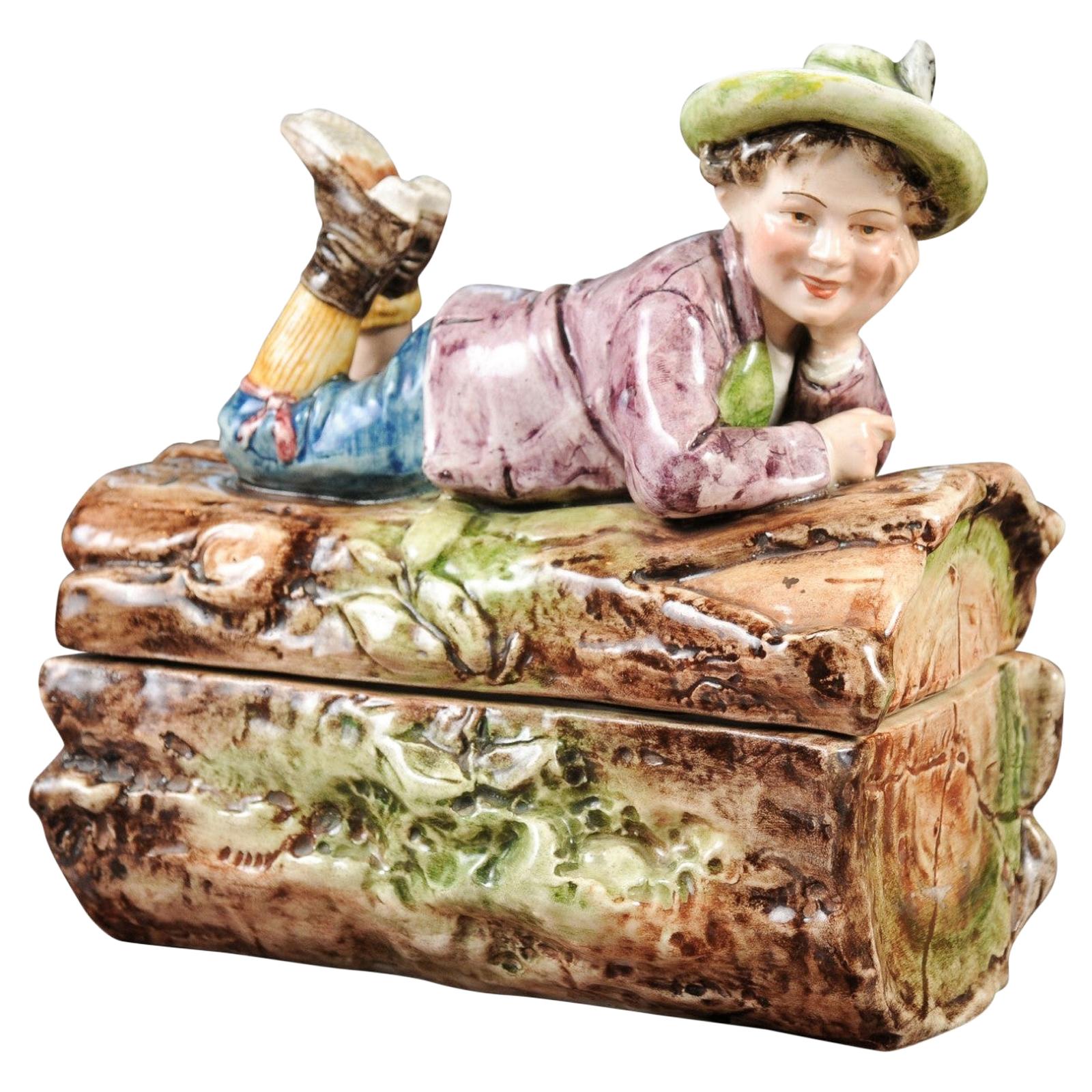 French 19th Century Barbotine Bonbon Box Depicting a Boy Laying on a Tree Trunk For Sale