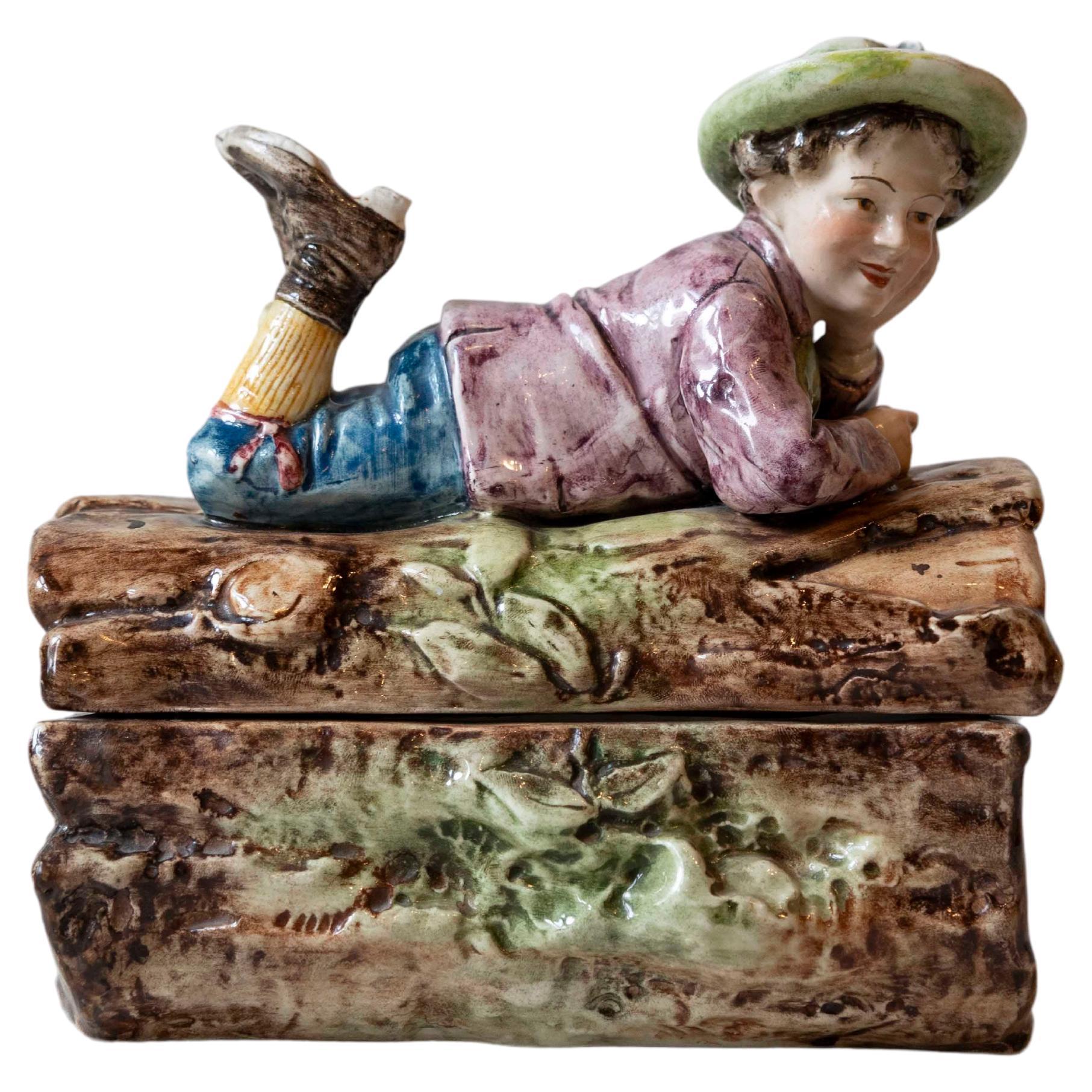 French 19th Century Barbotine Bonbon Box Depicting a Boy Laying on a Tree Trunk For Sale