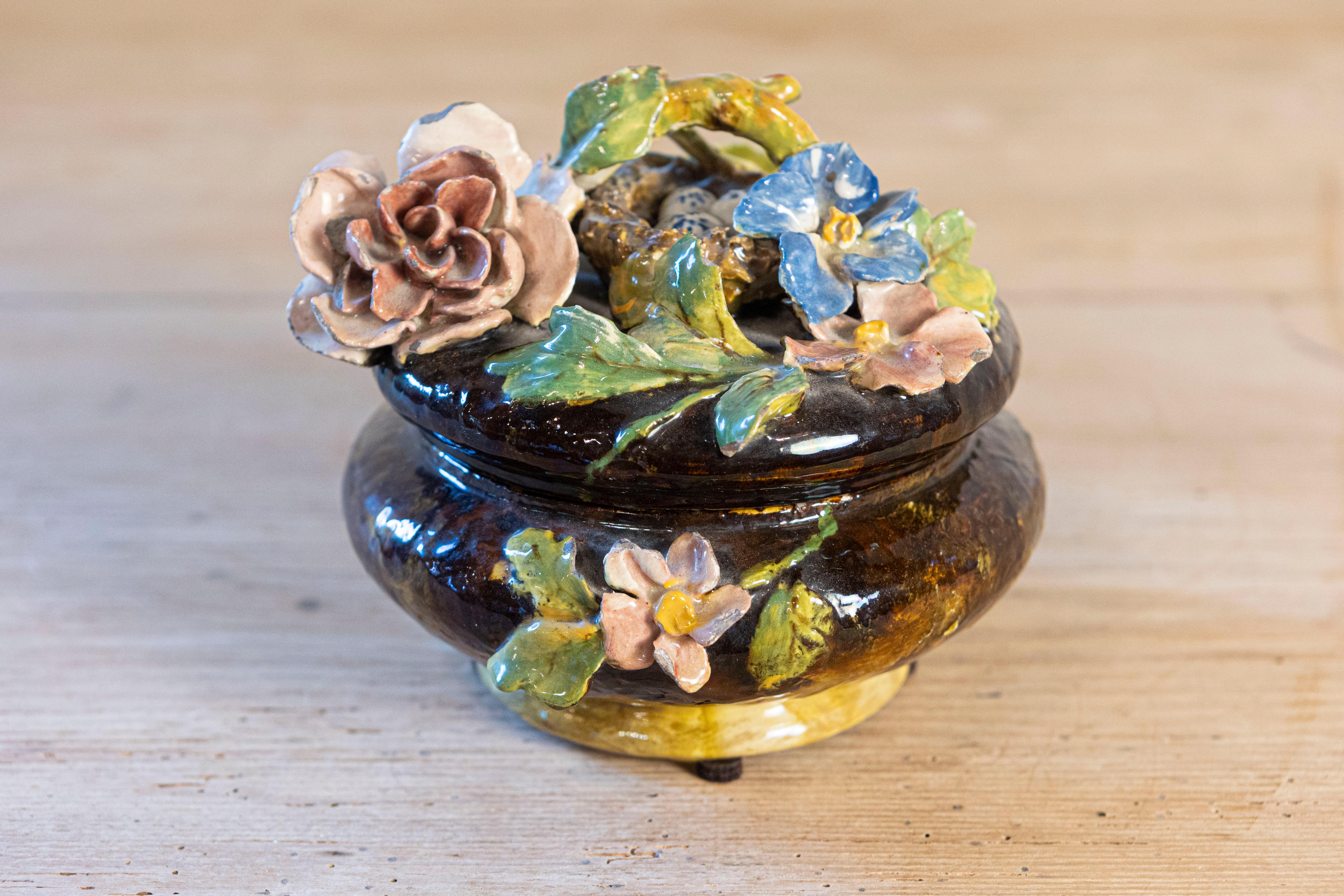 Petite coupe couverte en faïence française du XIXe siècle à décor de fleurs et de nids d'oiseaux en Barbotine. Cette exquise poterie française présente un corps rond brun foncé, orné d'un décor floral exubérant, typique des productions de la