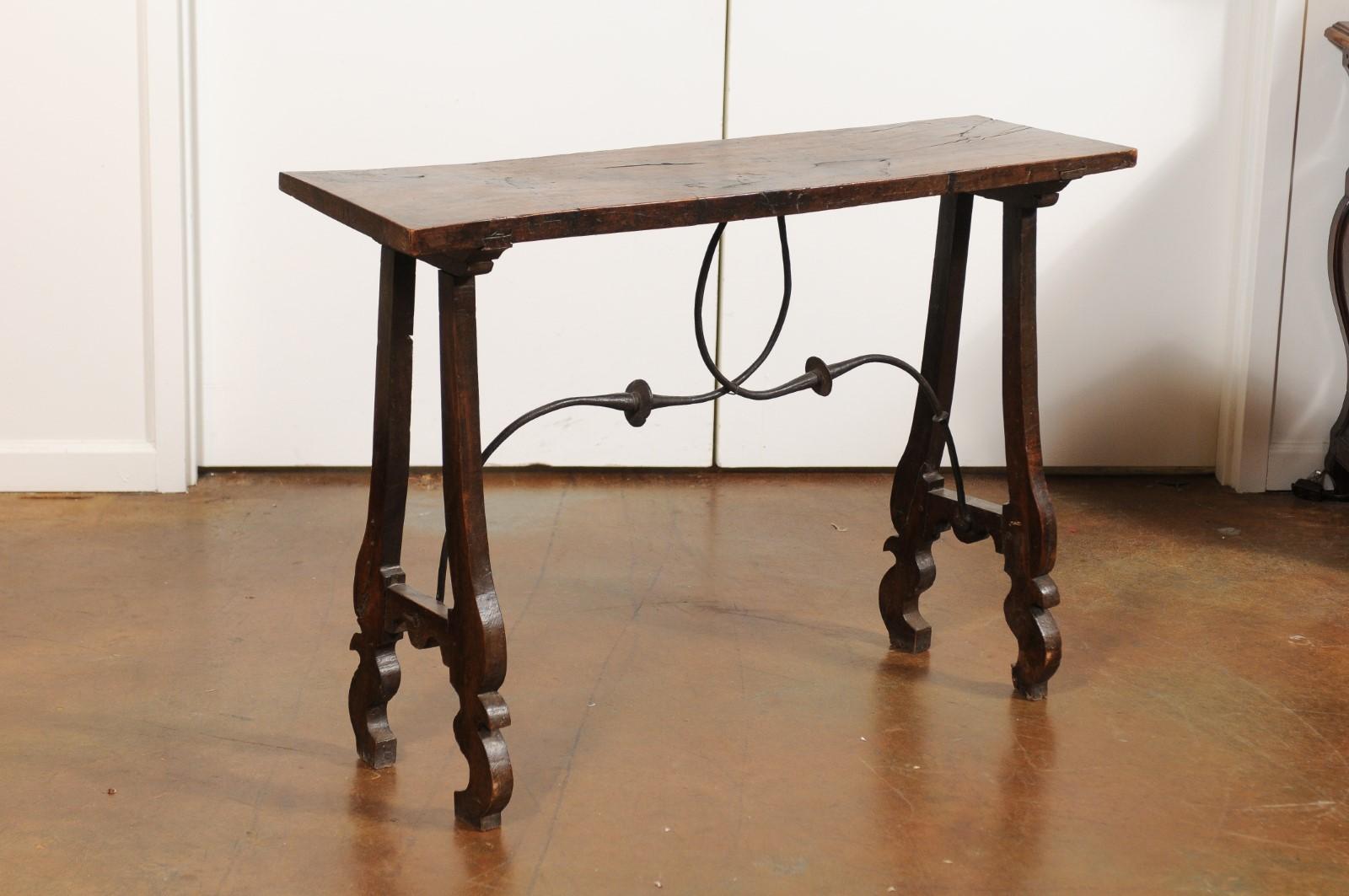 A French Baroque style walnut console table from the 19th century, with lyre-shaped legs and iron stretcher. Born in France during the every-changing 19th century, this console table features an exquisite rectangular single-plank walnut top with a