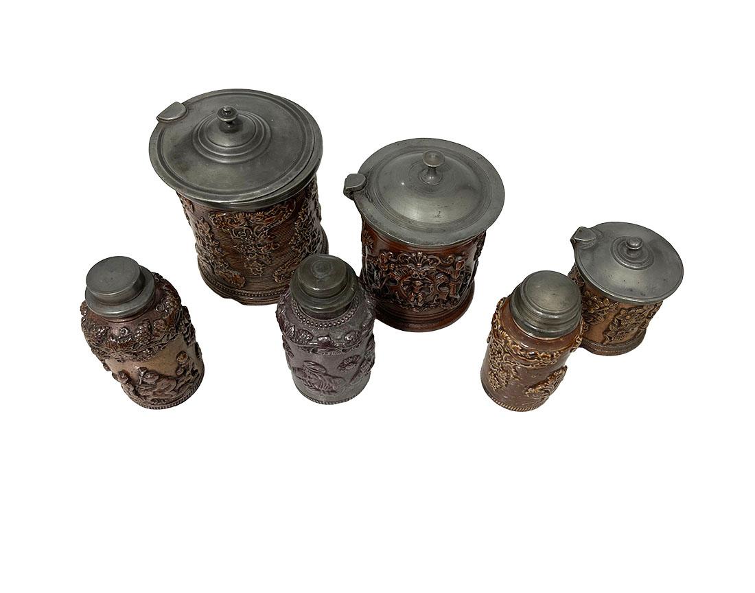 French 19th century Beauvais tobacco stoneware 

A collection of six stoneware pots, early 19th Century, raised decoration with salt glaze finish and pewter (hinged) lids. Three tobacco jars and three tobacco snuff bottles. One bottle still has an