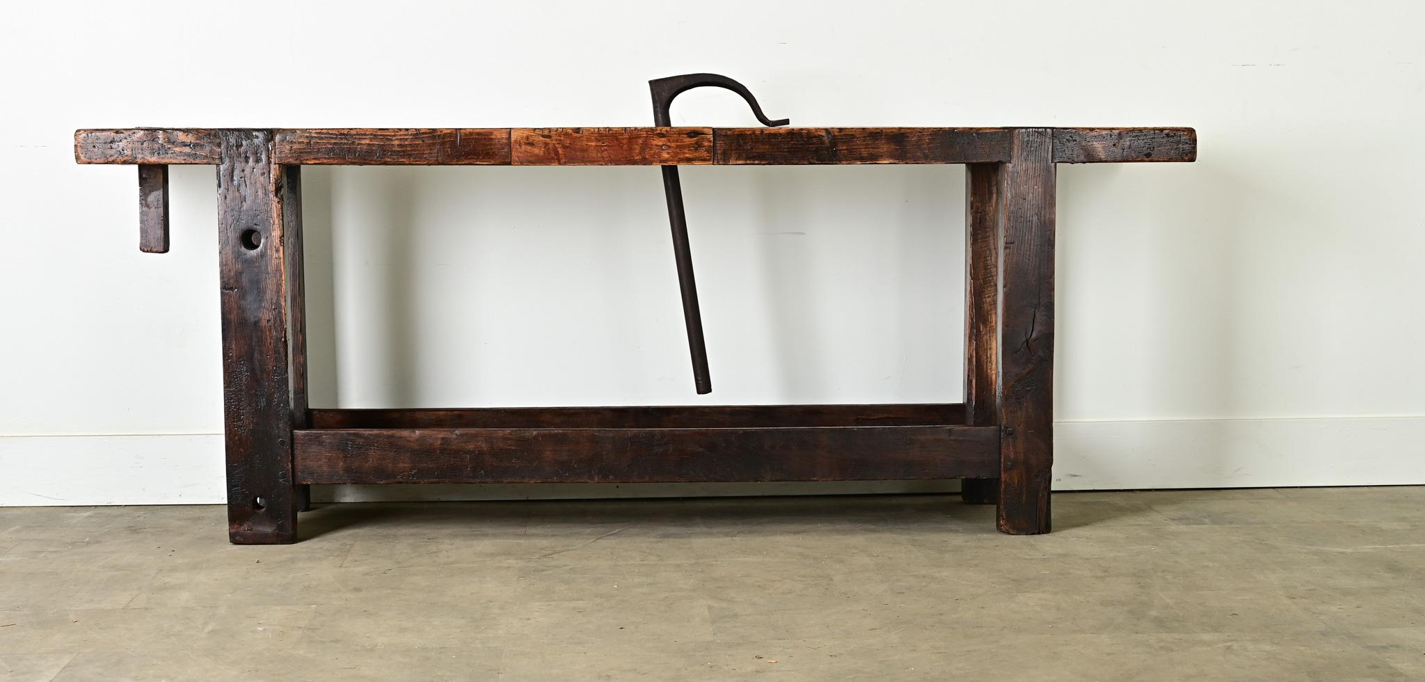 Unique carpenter’s bench from France, dating to the late 19th century, made of beech wood and iron. Protruding from the impressive, 2 ½” thick solid plank top, is a heavy iron rod which functions as a vise grip: the hook rests on the table surface