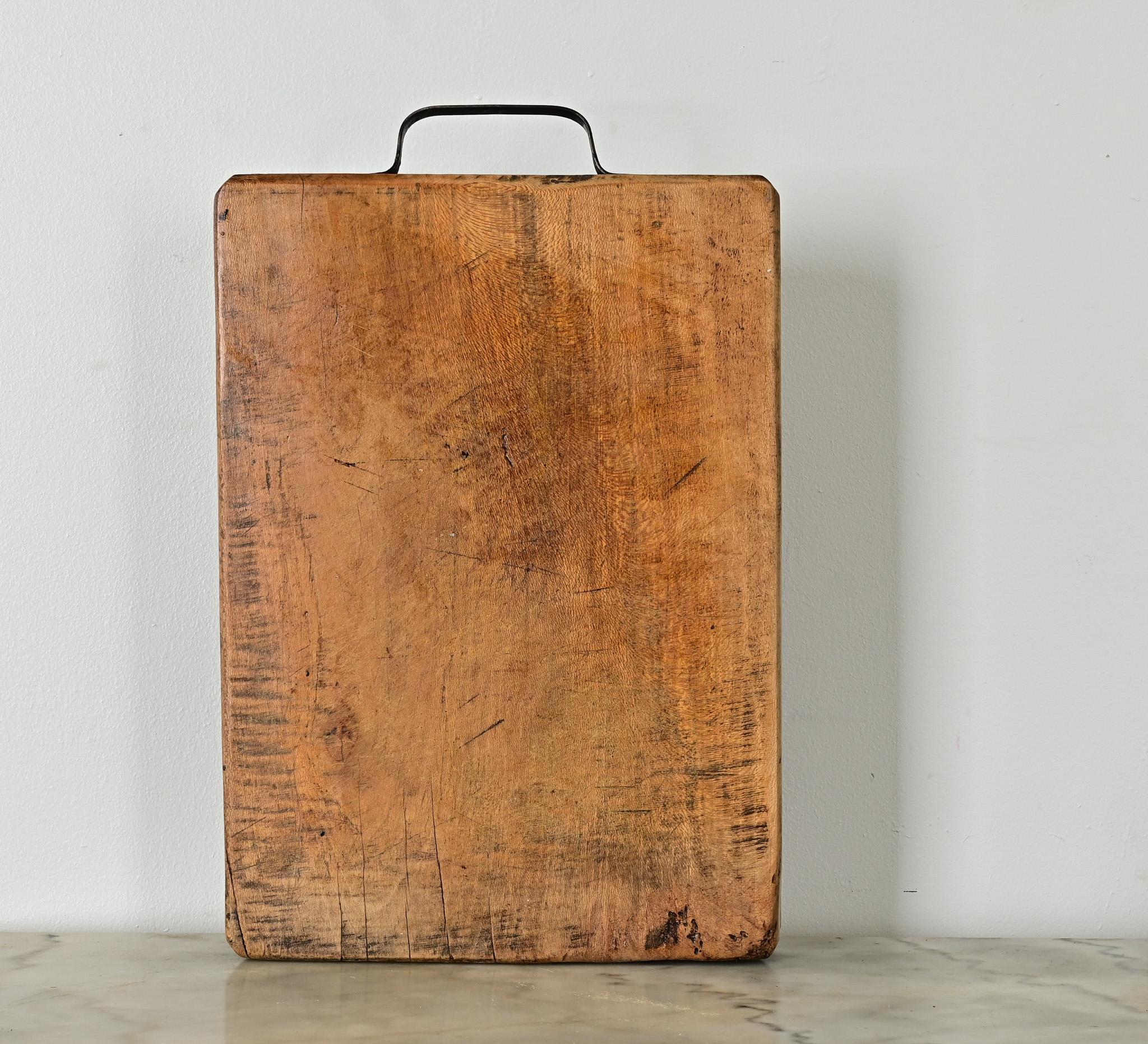 Esta tabla de picar de madera maciza de haya tiene una característica muy útil: un asa de acero en la parte superior para facilitar su transporte y almacenamiento. El bello dibujo de la veta sigue bastante claro tras unas marcas de picado muy