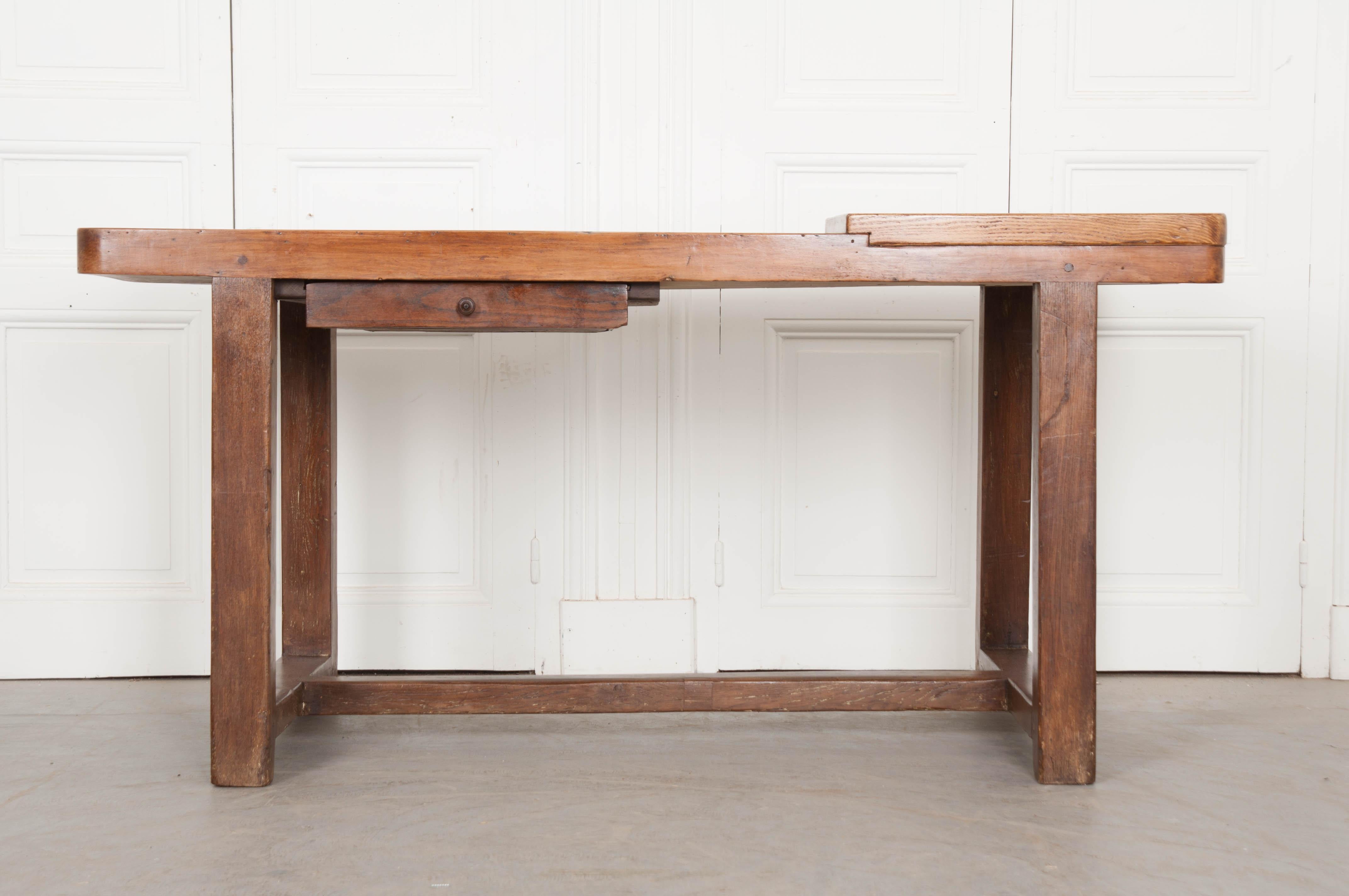 A Burgundian table for creating and enjoying! This exceptional French worktable features a beech top, with cutting board, and an oak base that is outfitted with a single drawer. The top has rounded corners and contains unique and thoughtful repairs