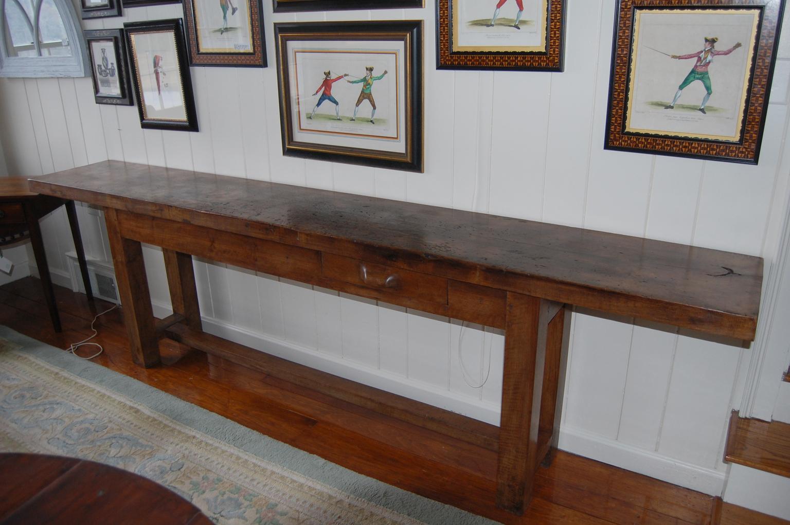 French provincial shoemaker's table or workbench from the Burgundy region of France. This beech wood workbench has a single thick beech removable top, and hunky beech square legs and H stretcher. The one drawer has an integrally carved handle. This