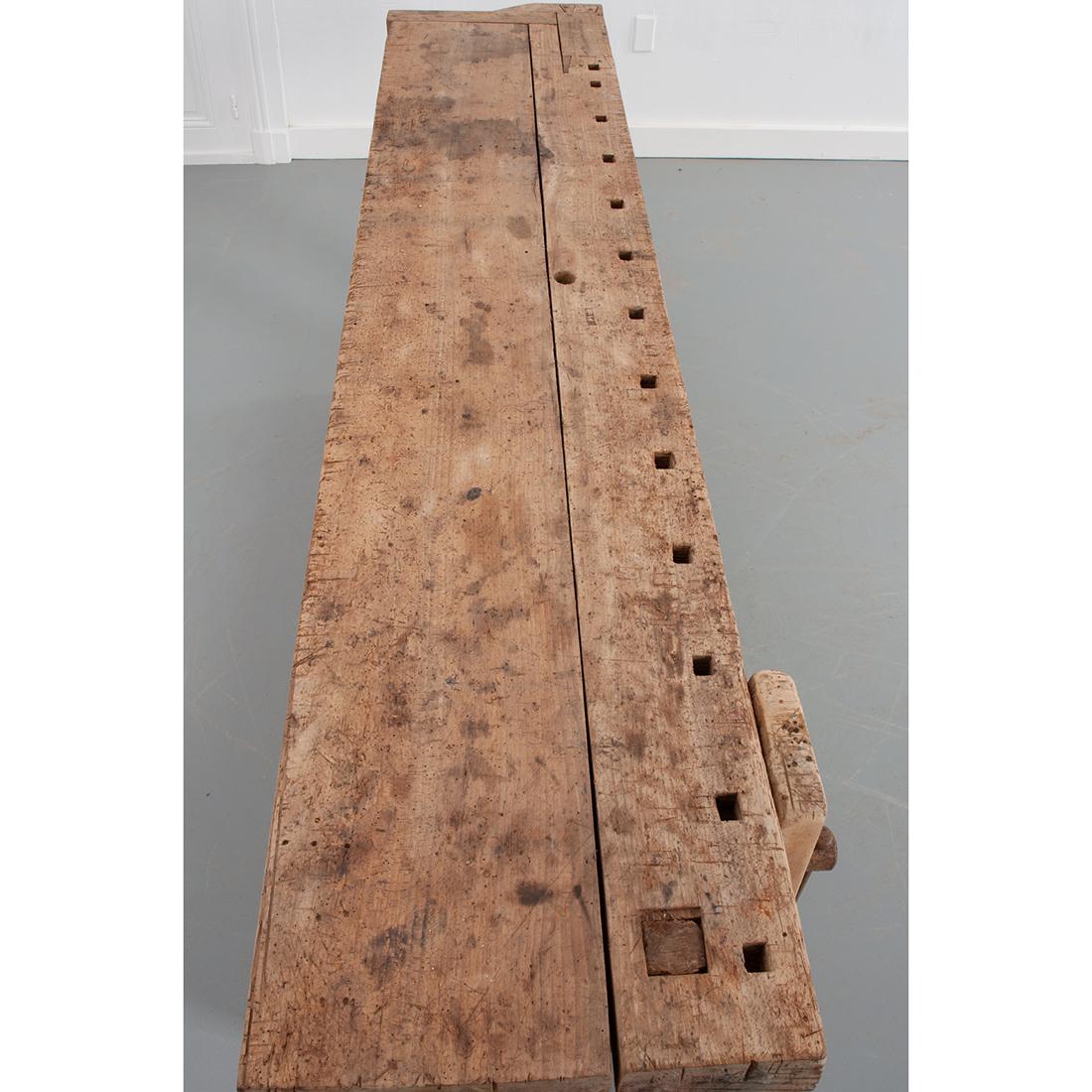 This Artisan’s bench from Burgundy France is made of unfinished beech and iron. Years of use shows on the surfaces of this table and its patina adds such character to this piece. It has two functional vises or clamps with hand forged iron turns and