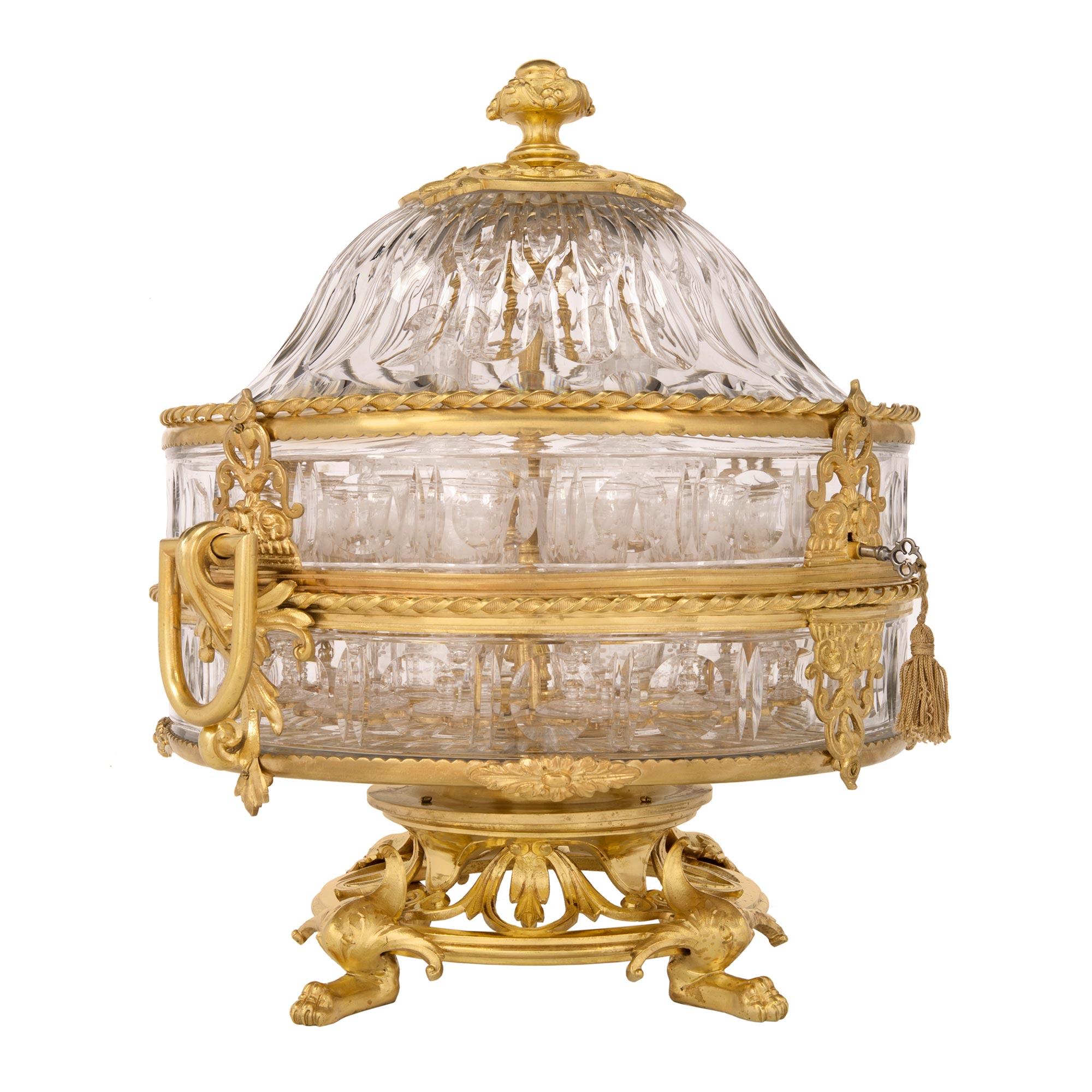 Superbe cave à liqueur en bronze doré et cristal de Baccarat, de style Louis XVI et d'époque Belle Époque, datant du 19e siècle, avec seize verres et quatre carafes. Ce magnifique service à liqueur est surélevé par de beaux pieds à pattes aux motifs