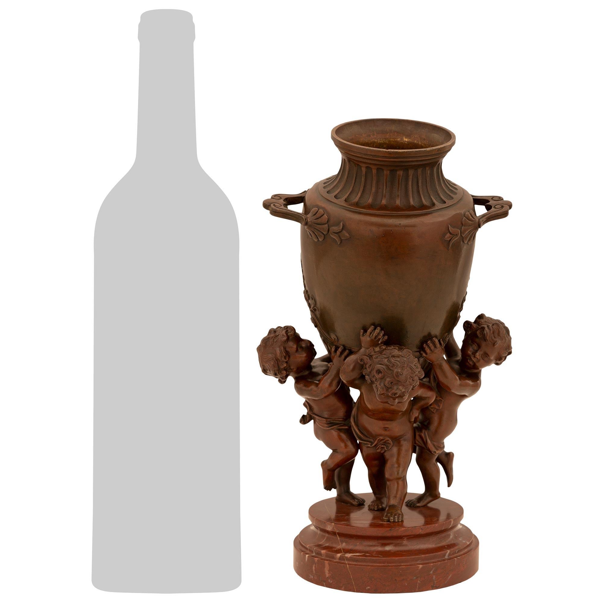 Squisita urna in bronzo patinato rosso e marmo Rouge Griotte di French Belle Epoque del XIX secolo, attribuita ad Augustuste Moreau. Questa affascinante urna in bronzo è sollevata da una base circolare in marmo Rouge Griotte dal bordo screziato.