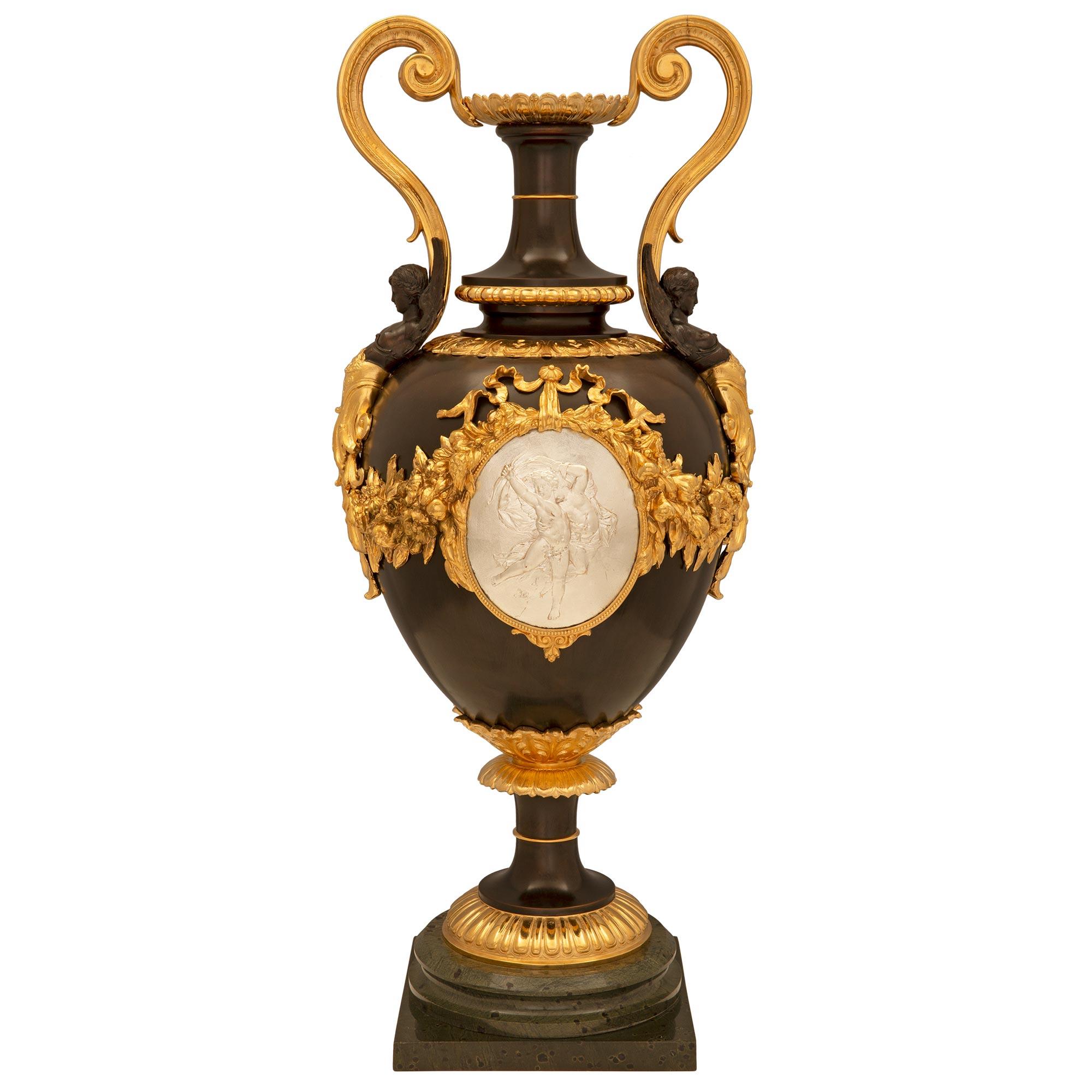 A stunning large scale French 19th century Louis XVI st. Belle Époque period patinated bronze, silvered bronze and ormolu urn. The urn is raised by a square base below a fine circular mottled wrap around band and a reeded ormolu band at the socle