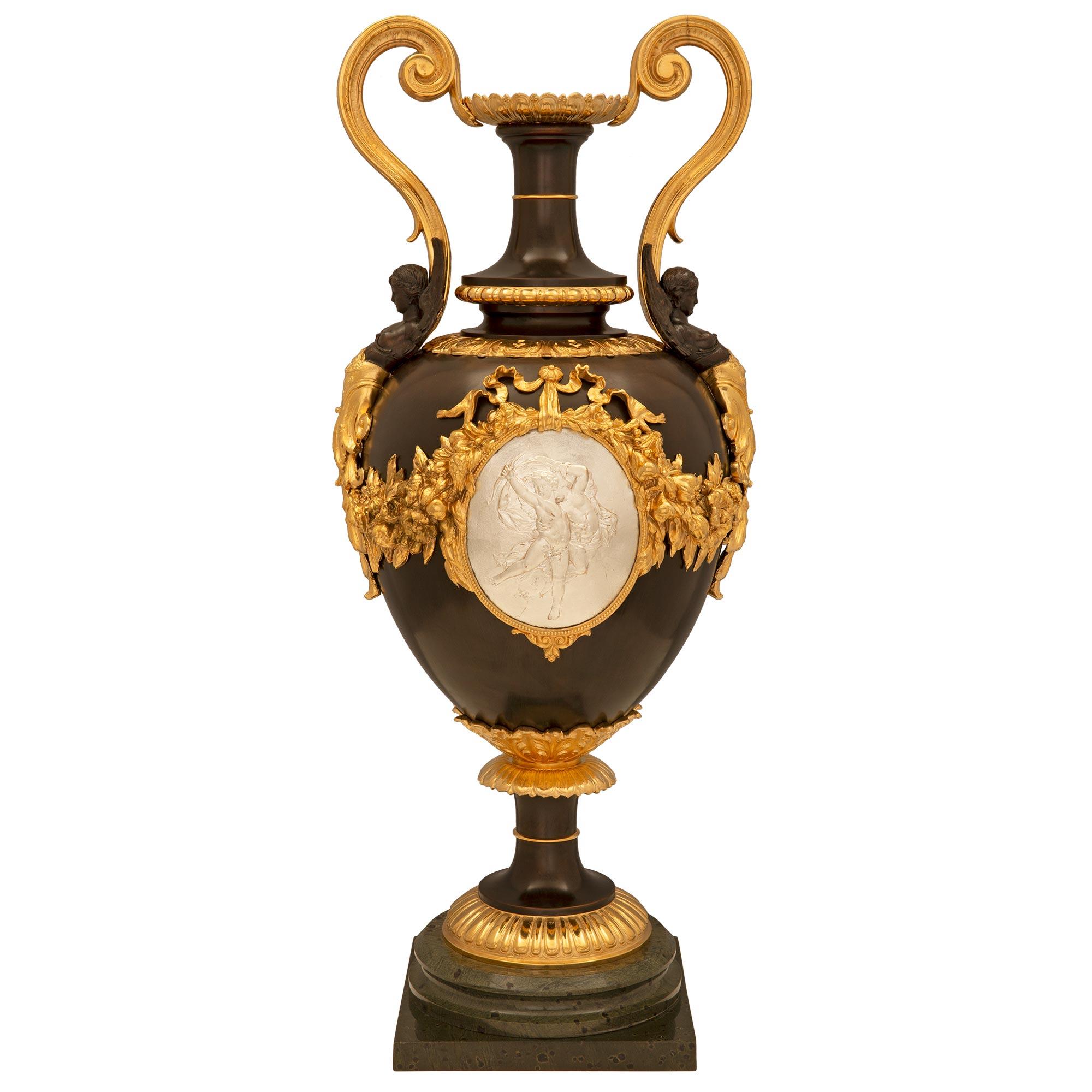 Splendida urna di grandi dimensioni in bronzo patinato, bronzo argentato e ormolo, risalente al XIX secolo, in stile Belle Époque. L'urna è sollevata da una base quadrata al di sotto di una sottile fascia circolare screziata che la avvolge e di una