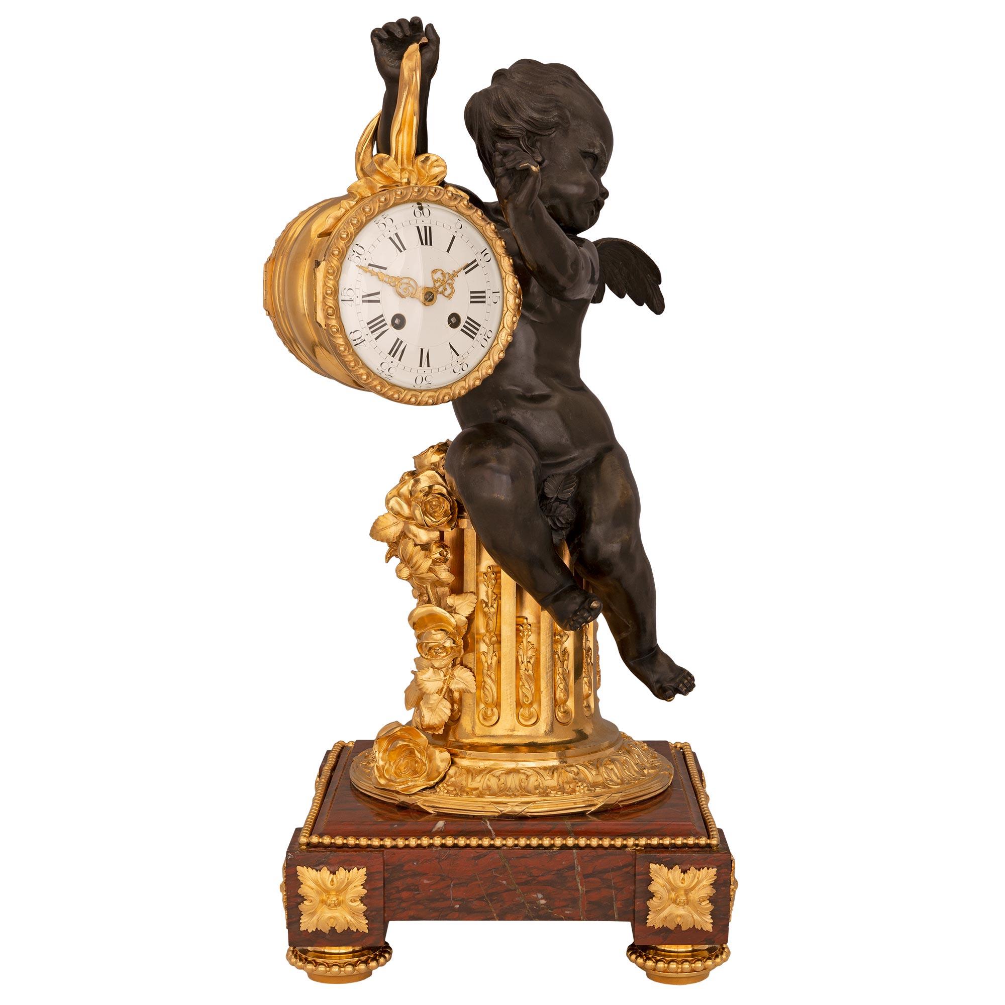 Superbe pendule en bronze patiné, bronze doré et marbre Rouge Griotte de très haute qualité, d'époque Louis XVI et Belle Époque, attribuée à Henry Dasson. L'horloge repose sur une remarquable base carrée en marbre Rouge Griotte avec des angles