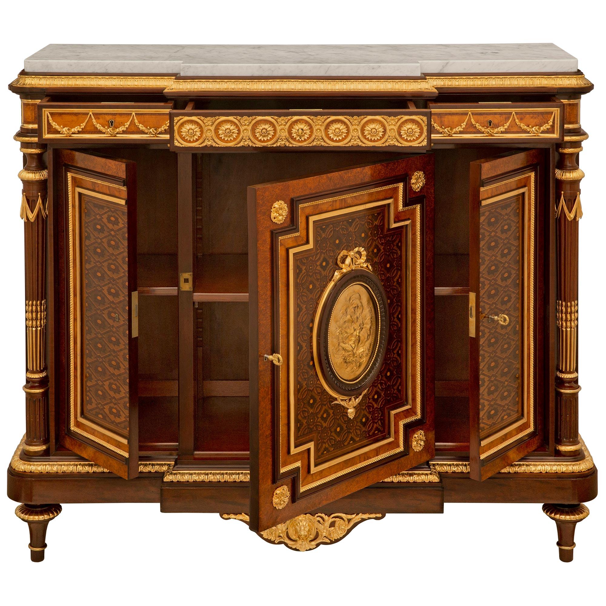 An exceptional and high quality French 19th century Louis XVI st. Belle Époque period Mahogany, Kingwood, Tulipwood, burl wood, ormolu and white Carrara marble cabinet possibly by Maison Krieger. The three door three drawer meuble à hauteur d'appui