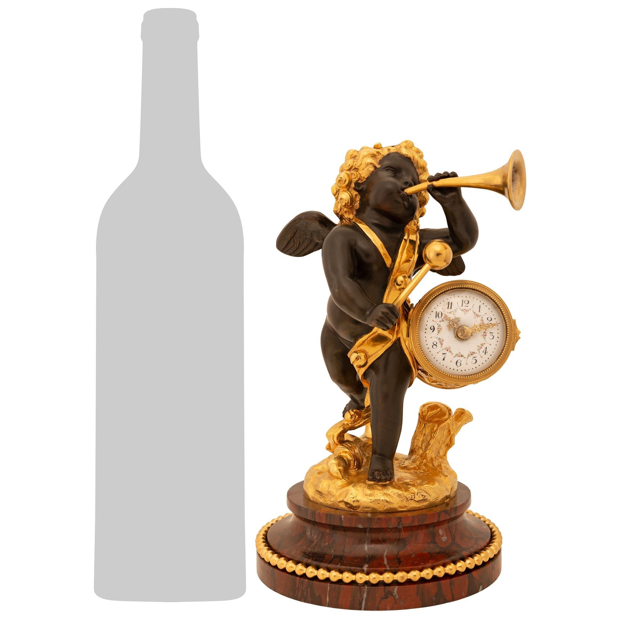 A lovely and high quality French 19th century Belle Époque period Louis XVI st. patinated Bronze, Ormolu, and Rouge Griotte marble clock, signed Falconet. This stunning miniature timepiece is raised by a mottled edge circular Rouge Griotte marble