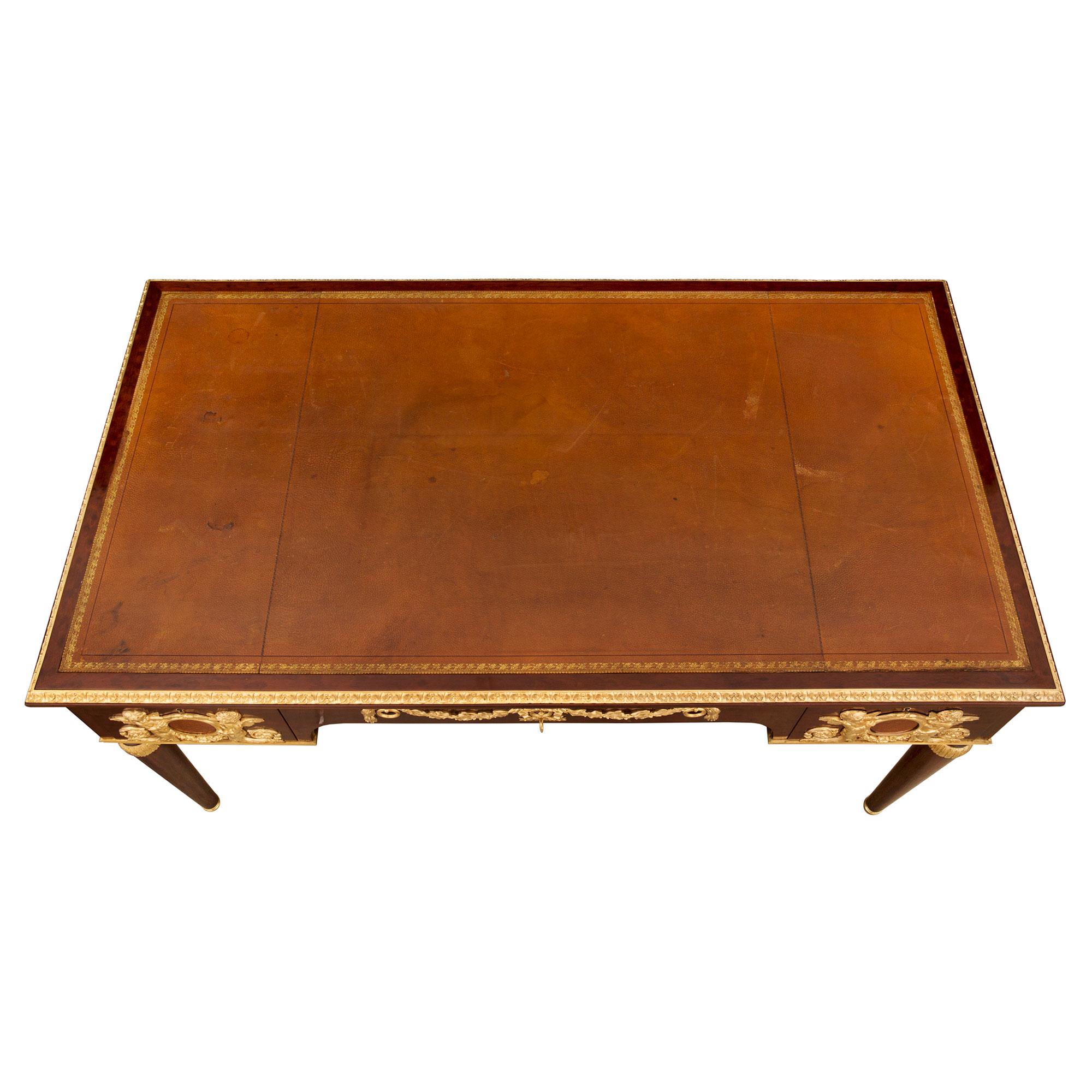 A handsome and most impressive French 19th century Louis XVI st. Belle Époque period mahogany, burl walnut and ormolu desk. The desk is raised by most elegant circular tapered legs with fine mottled ormolu sabots and lovely foliate top caps. The