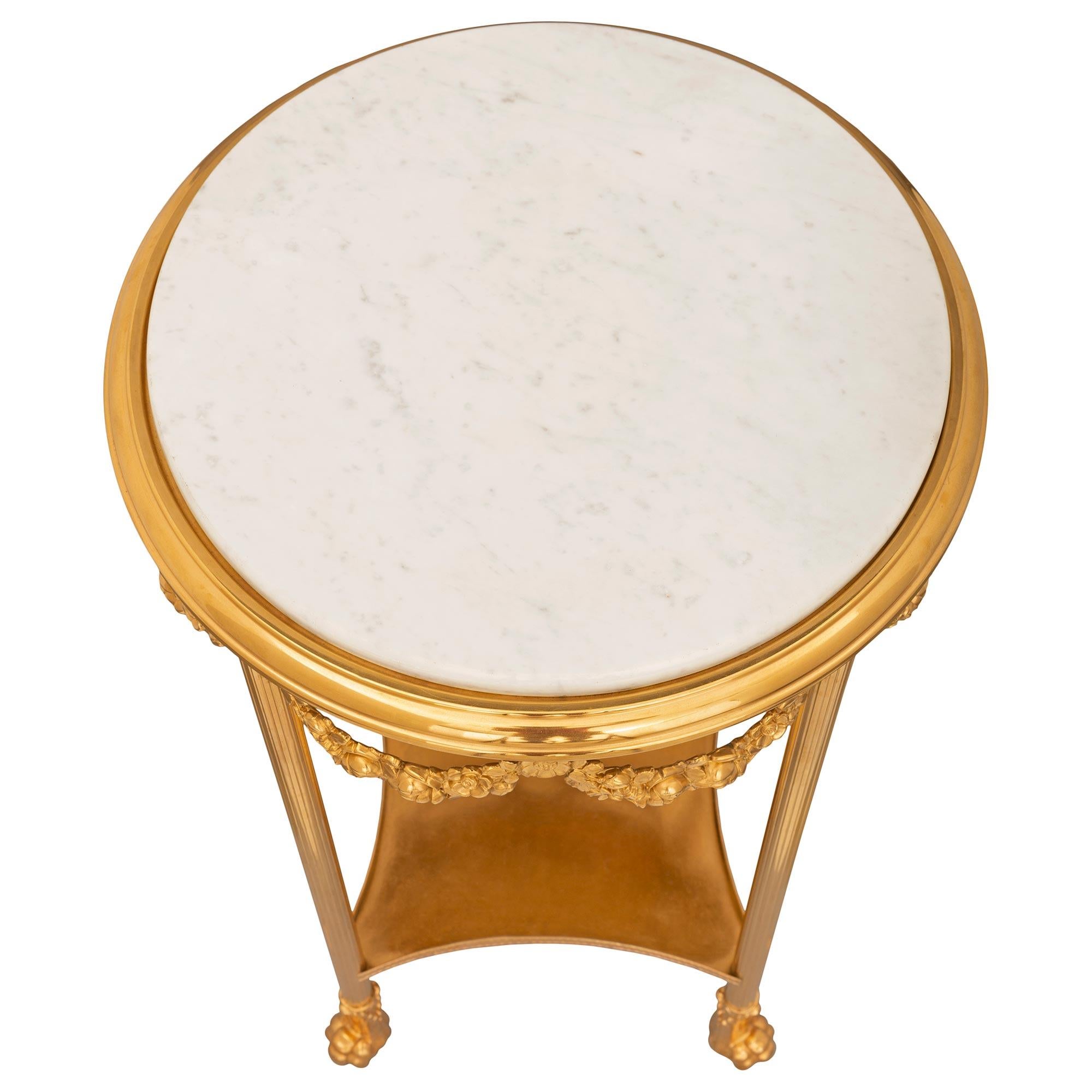 A remarkable French 19th century Neo-Classical St. Belle Époque period ormolu and white carrara marble side table. The circular table is raised by handsome paw feet with acanthus leaves below fluted circular legs connected by a most decorative