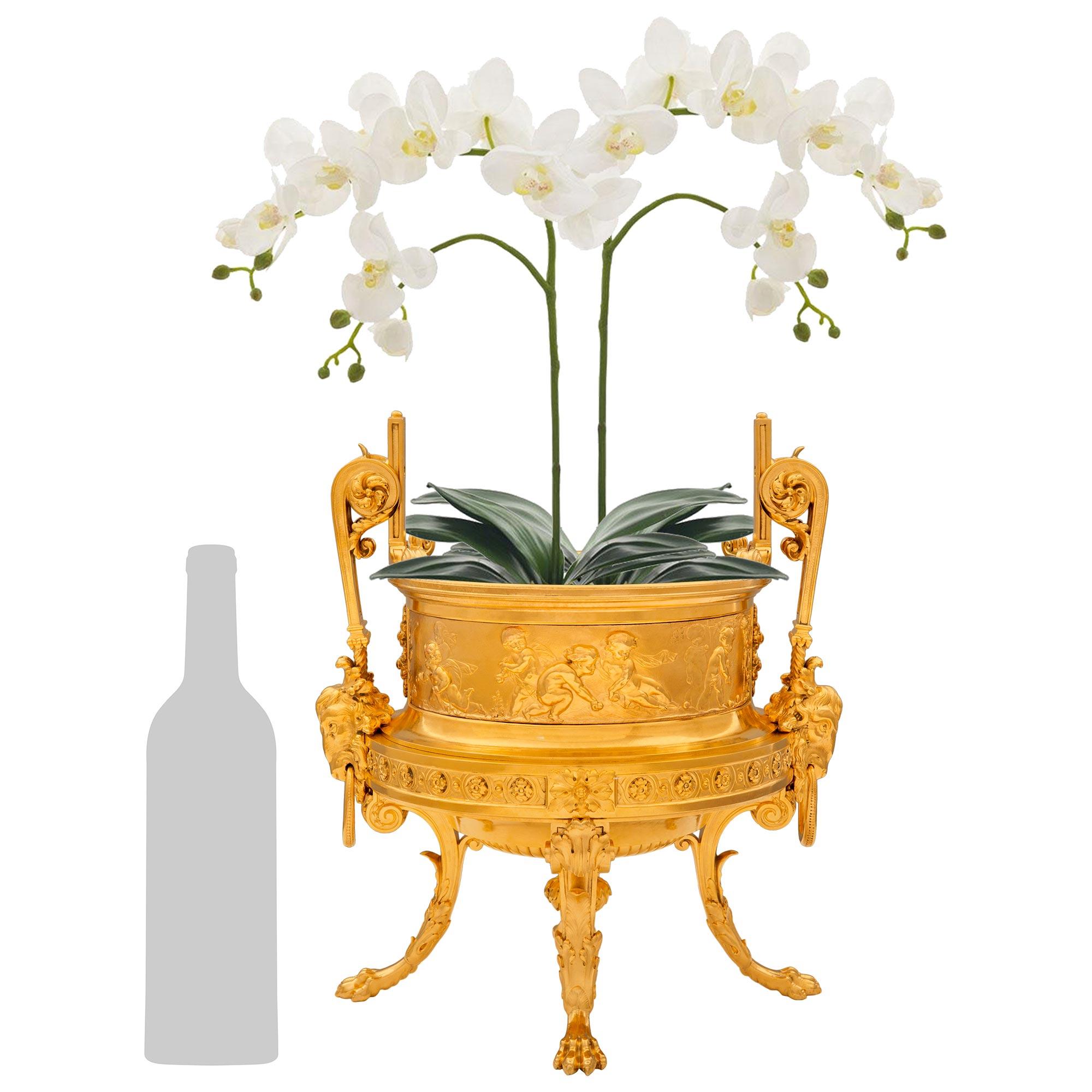 Une superbe urne de jardinière en bronze patiné et bronze doré, de style Clodion, datant de la période Belle Epoque. Ormolu et Bronze patiné, dans le style de Clodion. Cette très élégante jardinière/urne repose sur quatre pieds à volutes, avec des