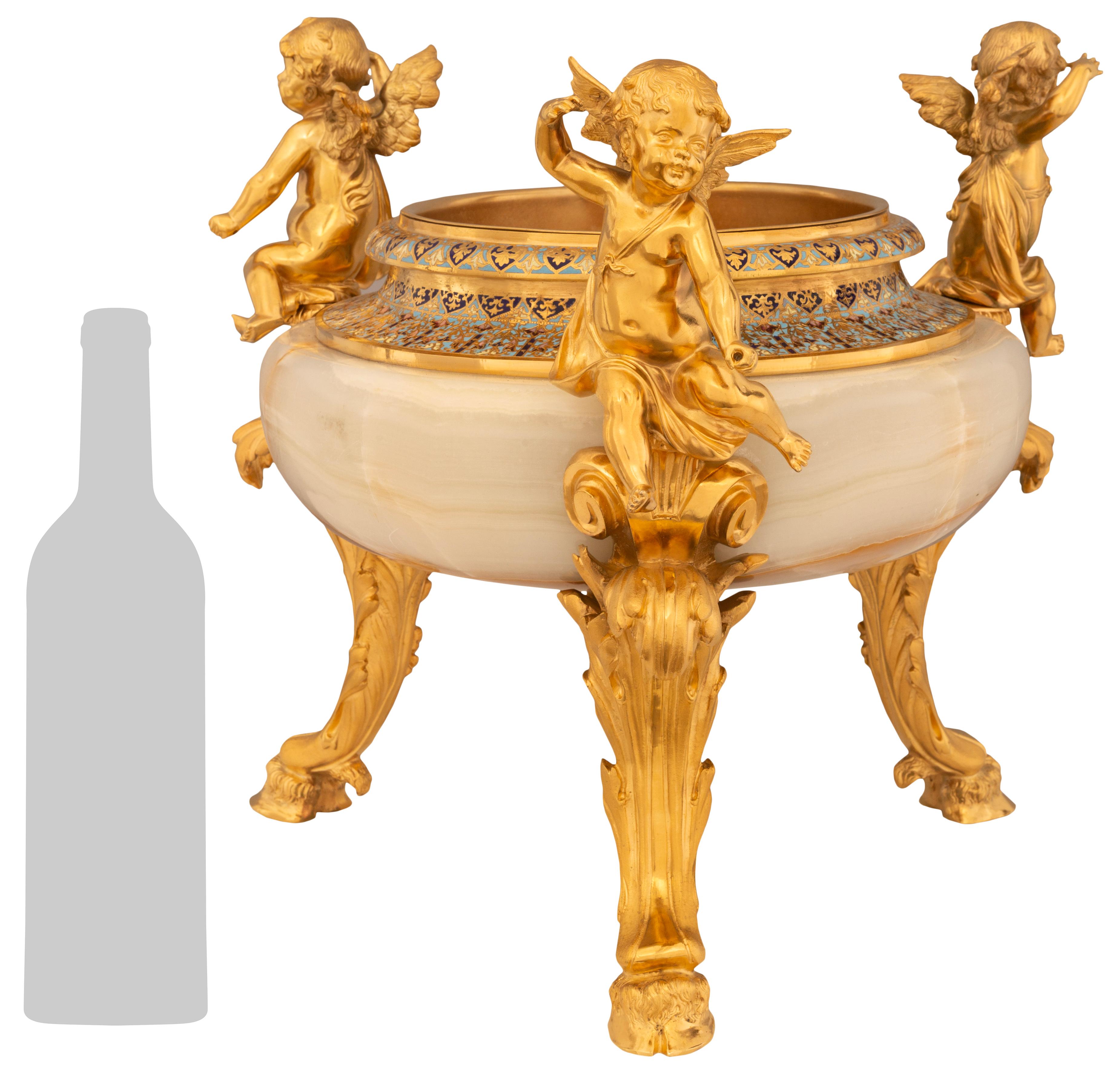 Una bellissima ed elegante fioriera da centrotavola in Onice, Cloisonné e Ormolu del XIX secolo di French Belle Epoque. Questo bellissimo centrotavola è sollevato da tre gambe a 'C' di Ormolu con foglie d'acanto e piedini a zoccolo. In cima a
