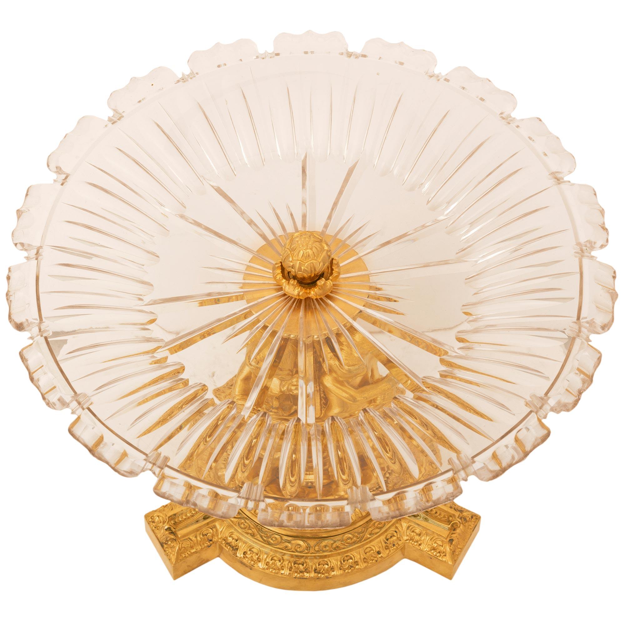 A most elegant French 19th century Louis XVI St. Belle Époque period ormolu and Baccarat crystal centerpiece. The centerpiece is raised by a circular base with three protruding reserves decorated with beautiful finely detailed mottled wrap around