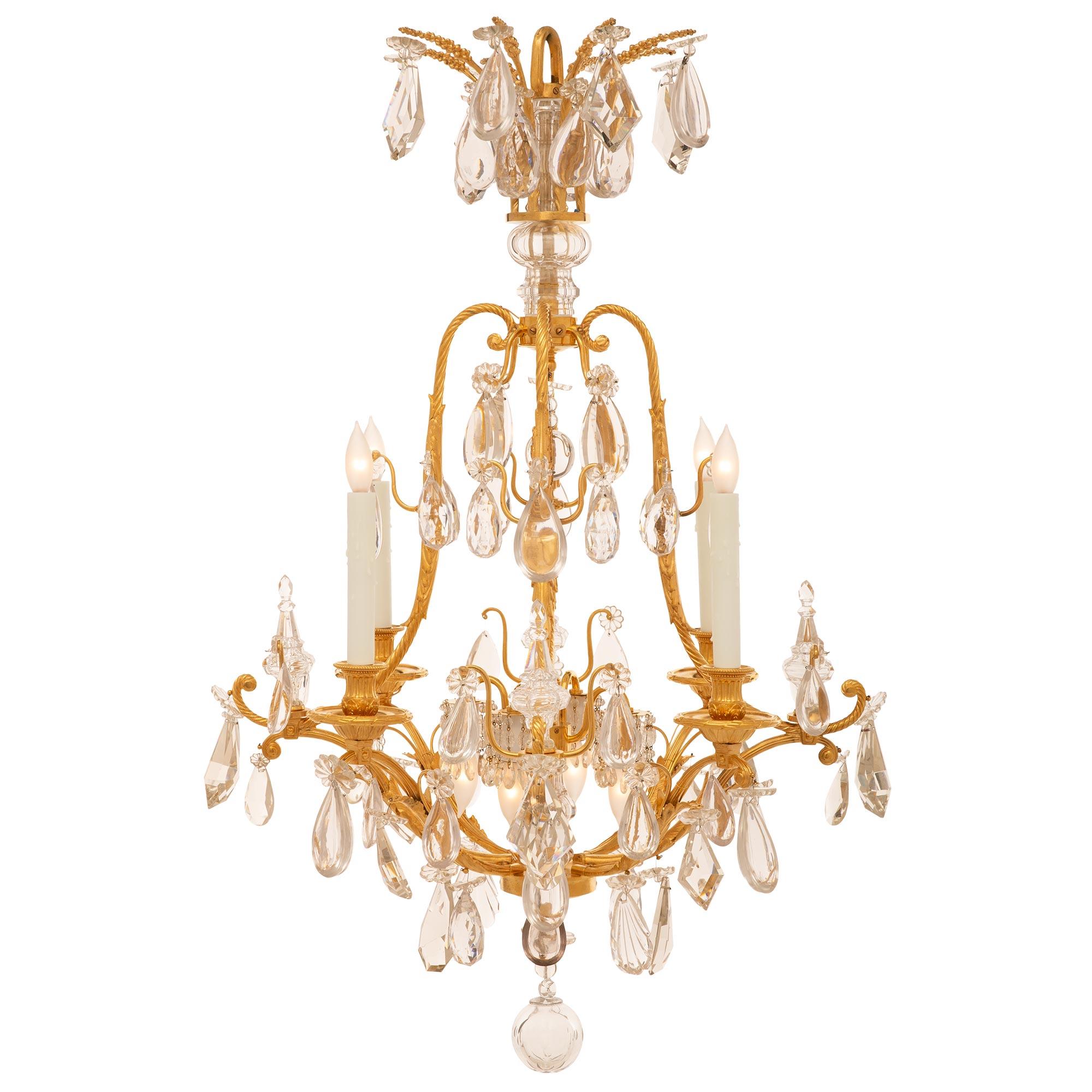 A stunning French 19th century Louis XVI st. Belle Époque period ormolu and Baccarat crystal chandelier. The four arm eight light chandelier is centered by an elegant bottom crystal ball amidst an exceptional array of seashell, teardrop, and kite