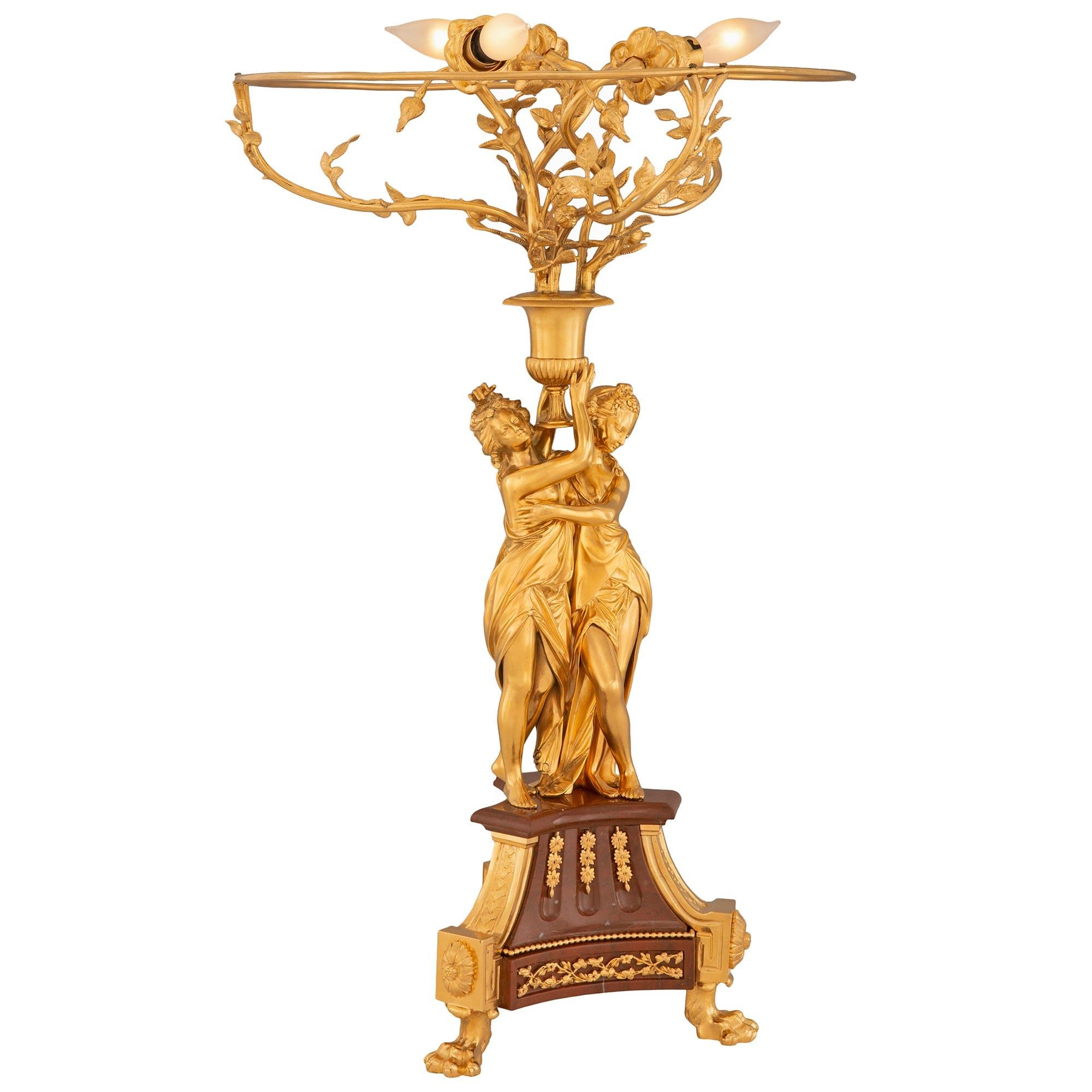 An exceptional and large scale French 19th century Louis XVI st. Belle Époque period ormolu and Rouge Griotte marble lamp. The lamp is raised by three impressive paw feet below striking block rosettes and fine curved ormolu bands encasing the fluted