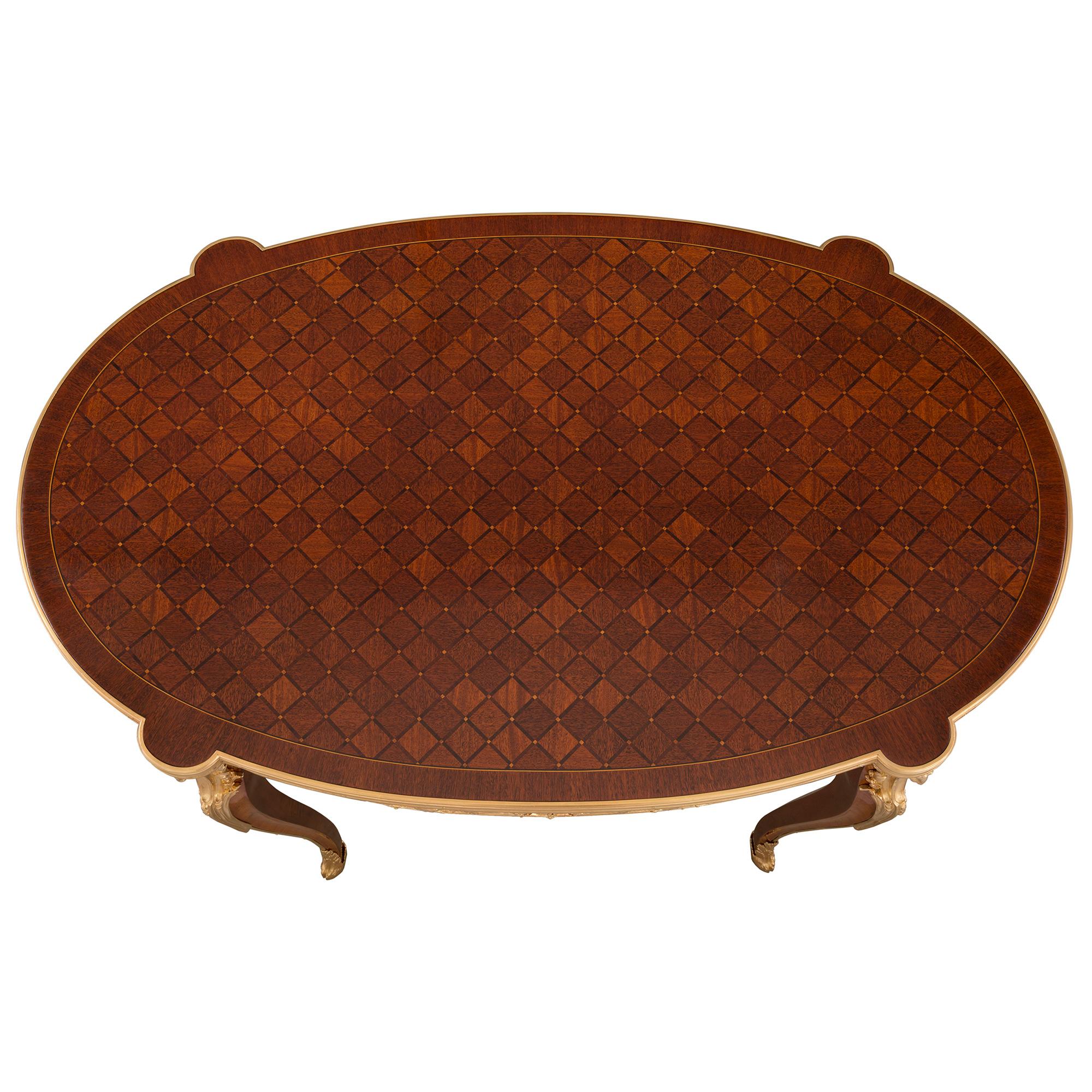An exquisite French 19th century Louis XV st. Belle Époque period mahogany and ormolu oval side table/desk, signed Paul Sormani. The table is raised by slender cabriole legs with fine foliate wrap around sabots, hoof feet and with elegant ormolu
