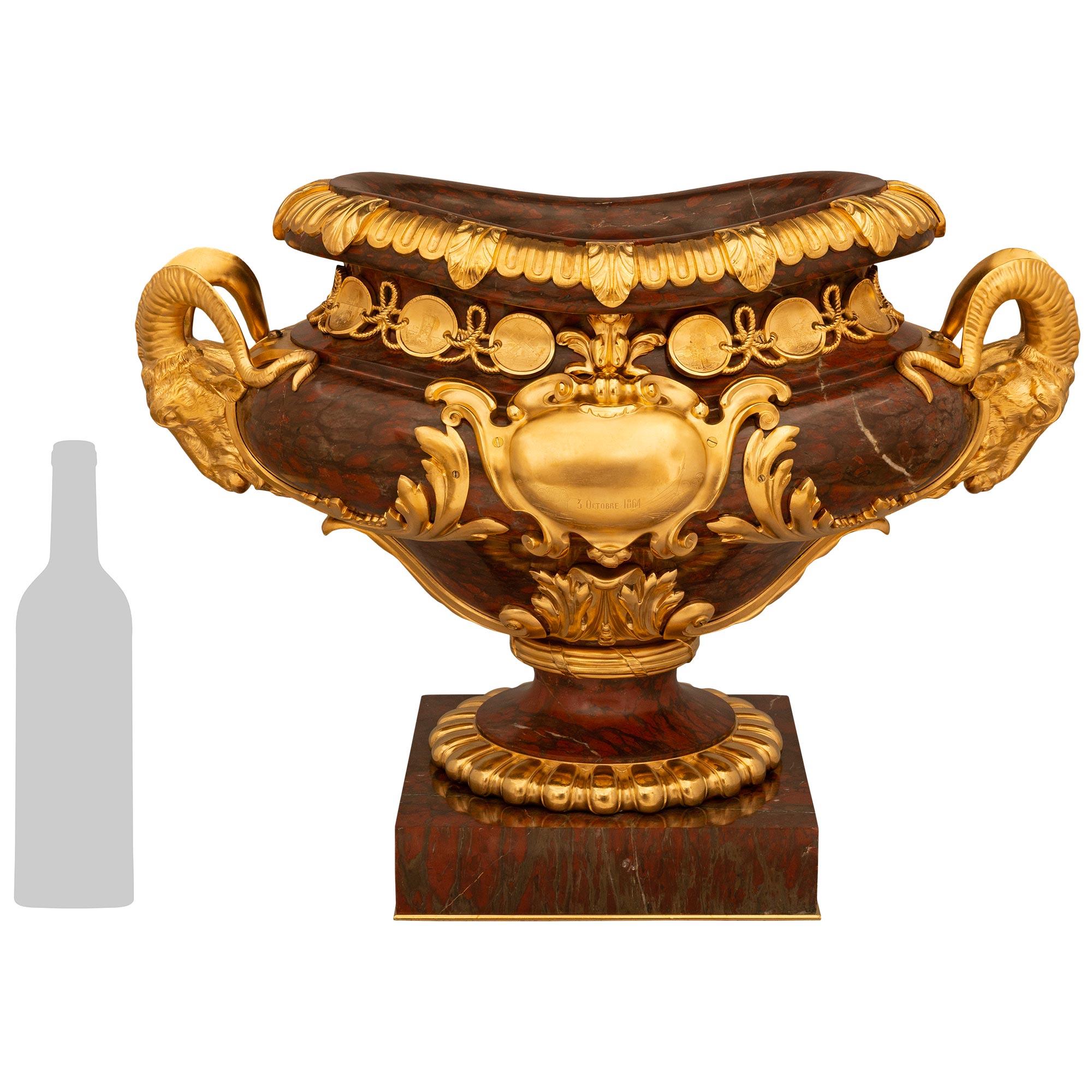 A stately and statement making French 19th century Belle Epoque period Rouge Griotte marble and Ormolu centerpiece/urn, in the manner of Barbedienne. This large scale centerpiece is raised on a marble base while being supported by an Ormolu base