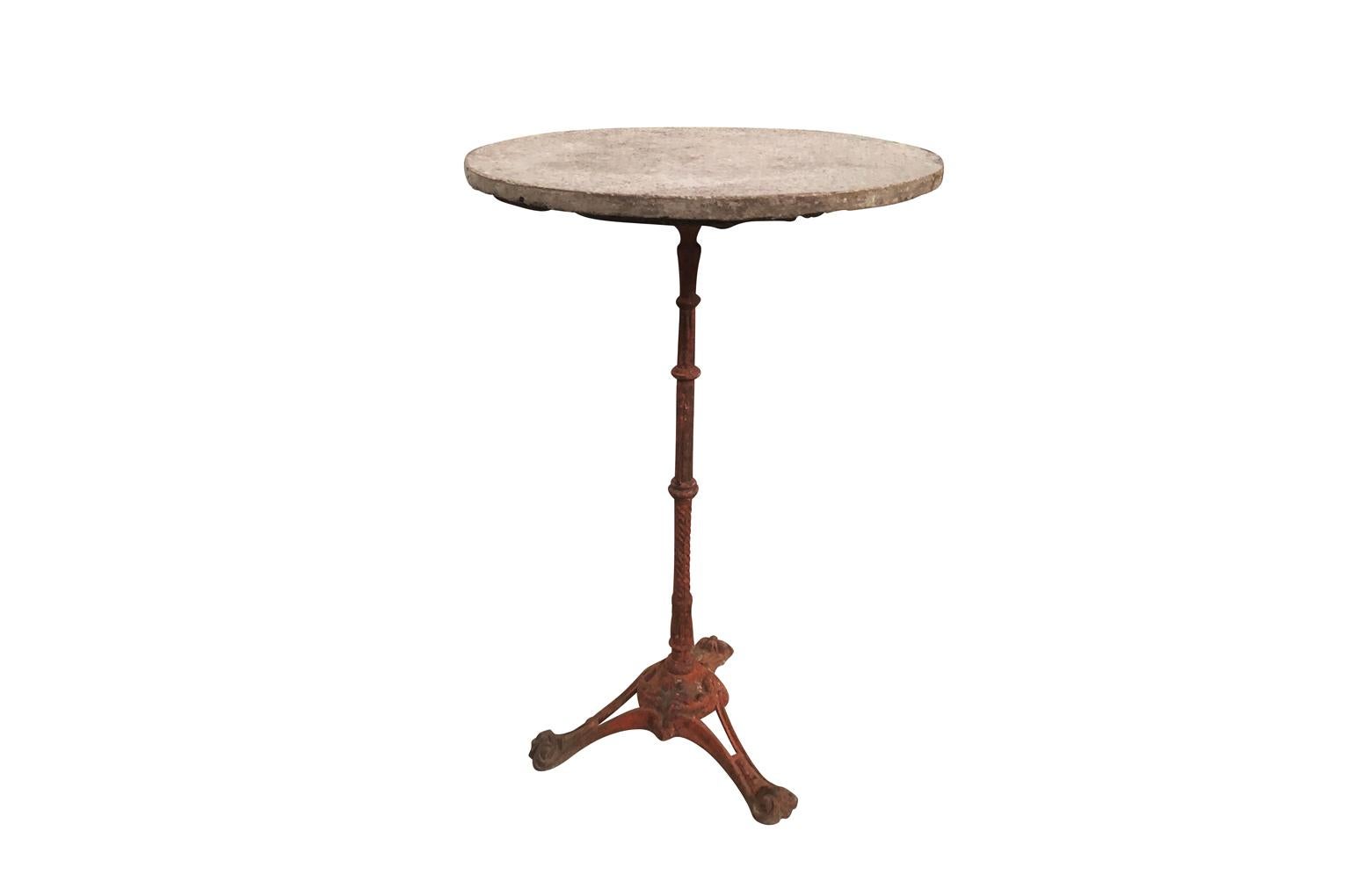 A delightful later 19th century French Bistro Gueridon. This more unique bistro table is composed of beautifully painted cast iron base and a lovely stone top. Super patina. The bistro table will and charm and character to any garden or interior.