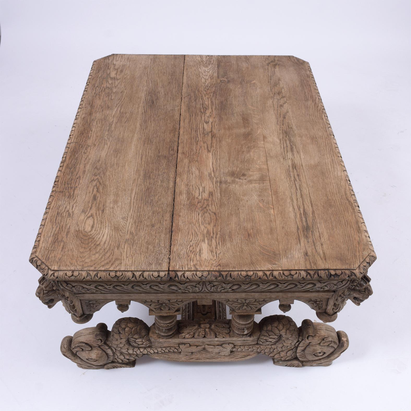 This Antique Renaissance Low Coffee Table is made out of solid oakwood, comes with a large rectangular top with a single drawer, and detailed hand-carved moldings throughout the piece. This table features interact hand-carved lion heads on the