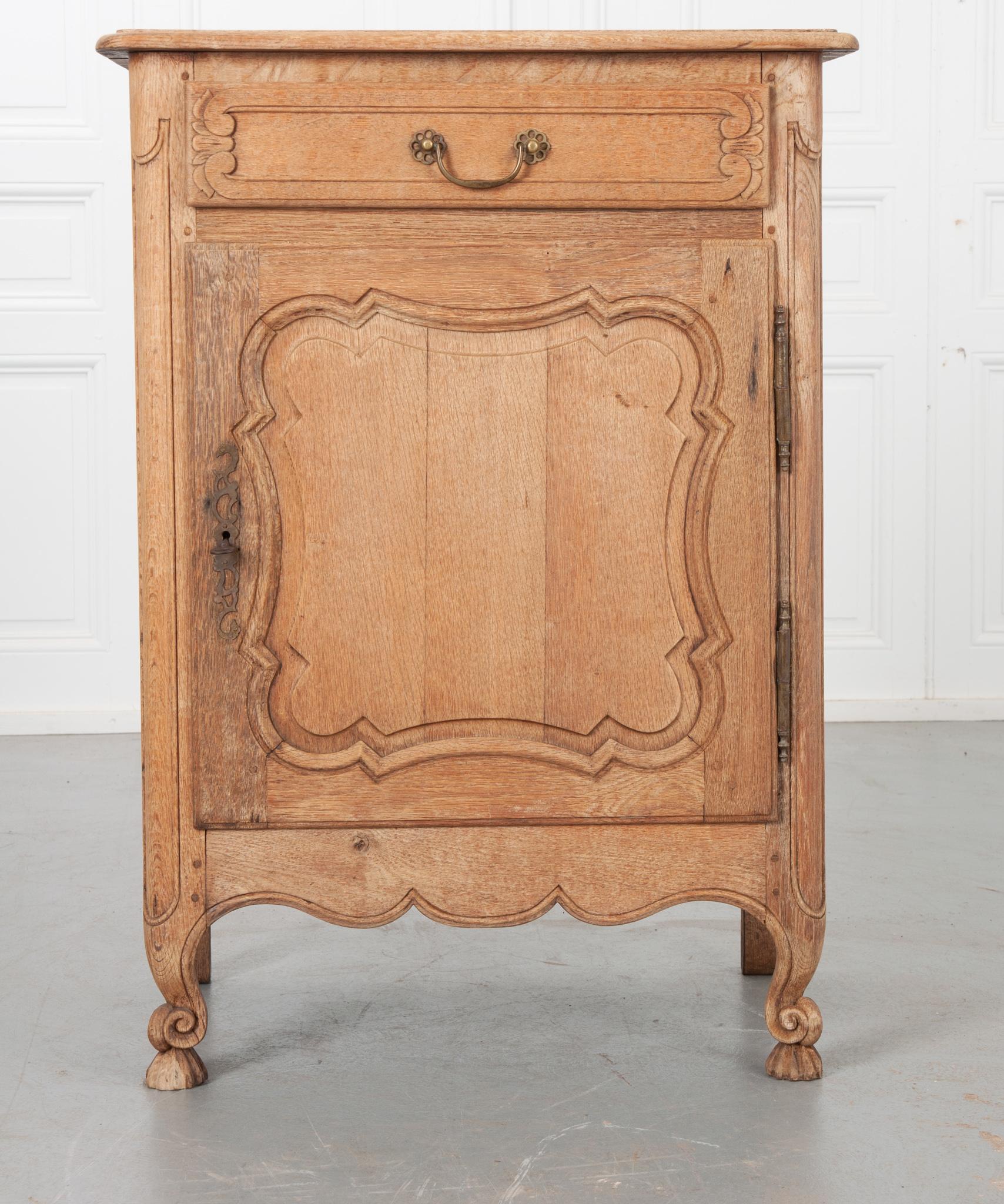 This is a fine example of a French Louis XV style confiture, a single door cabinet used to store jams or other preserved foods. The whole is made of beautifully aged oak that’s been bleached to enrich the overall appearance. Three cut boards with
