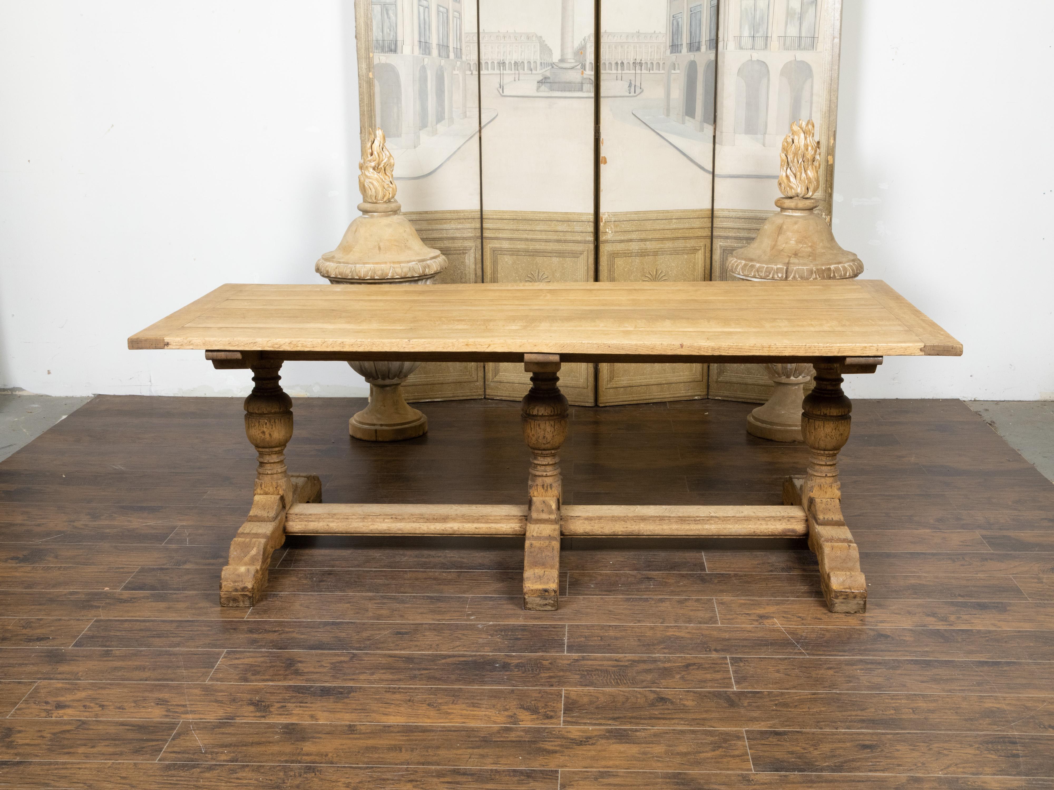 Blanchi Table de ferme française du 19ème siècle en chêne blanchi avec base à tréteaux et pieds à balustre en vente