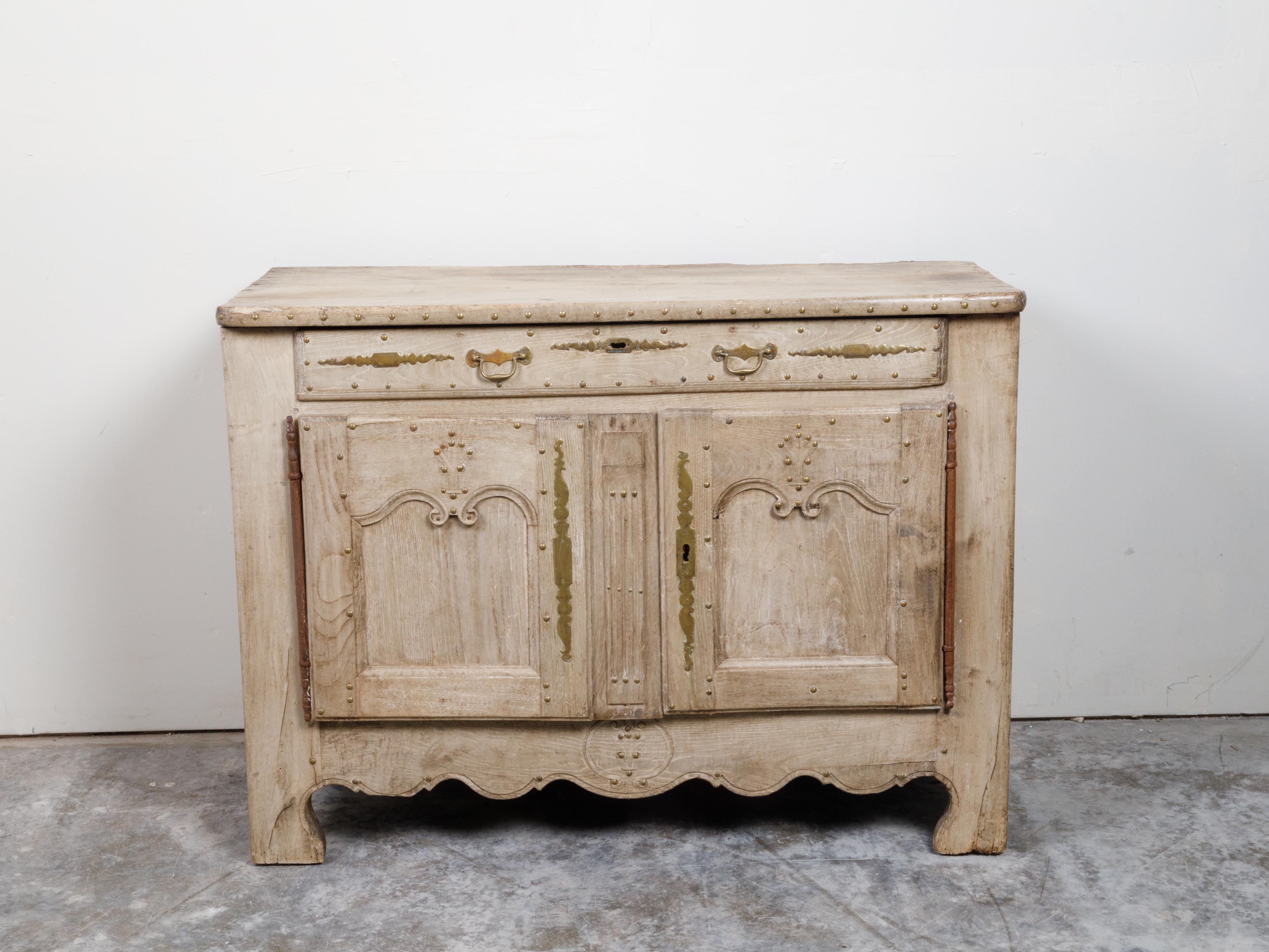 Un buffet francese in legno sbiancato risalente al XIX secolo, con grembiule intagliato e patina ben distinta. Creato in Francia nel XIX secolo, questo buffet in legno sbiancato presenta un piano rettangolare con angoli arrotondati e borchie in
