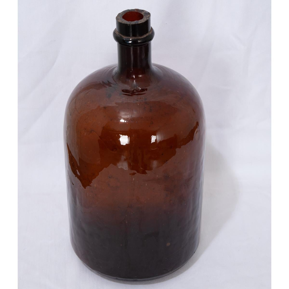 This small, brown, blown glass wine keg, or demijohn as they are sometimes called, remains fully intact after more than one hundred years. Still in wonderful condition, this piece would be a great addition to your space, giving it an element of