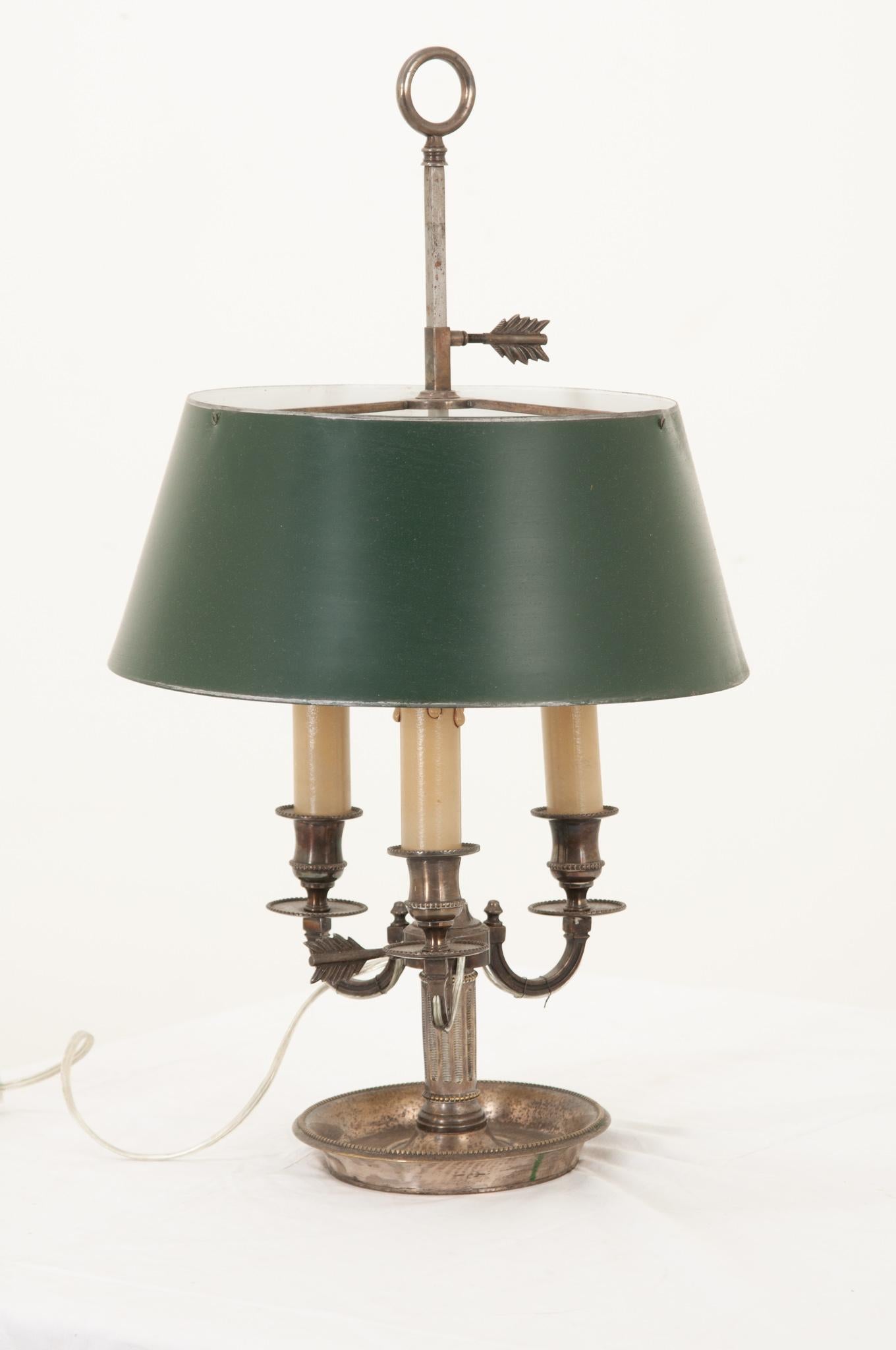 French Bouillotte lamp with its original painted green tole shade. Bouillotte is a card game that became popular in France during the 18th & 19th centuries. For light, they would use a bouillotte lamp. This particular one is brass with 3 candelabra