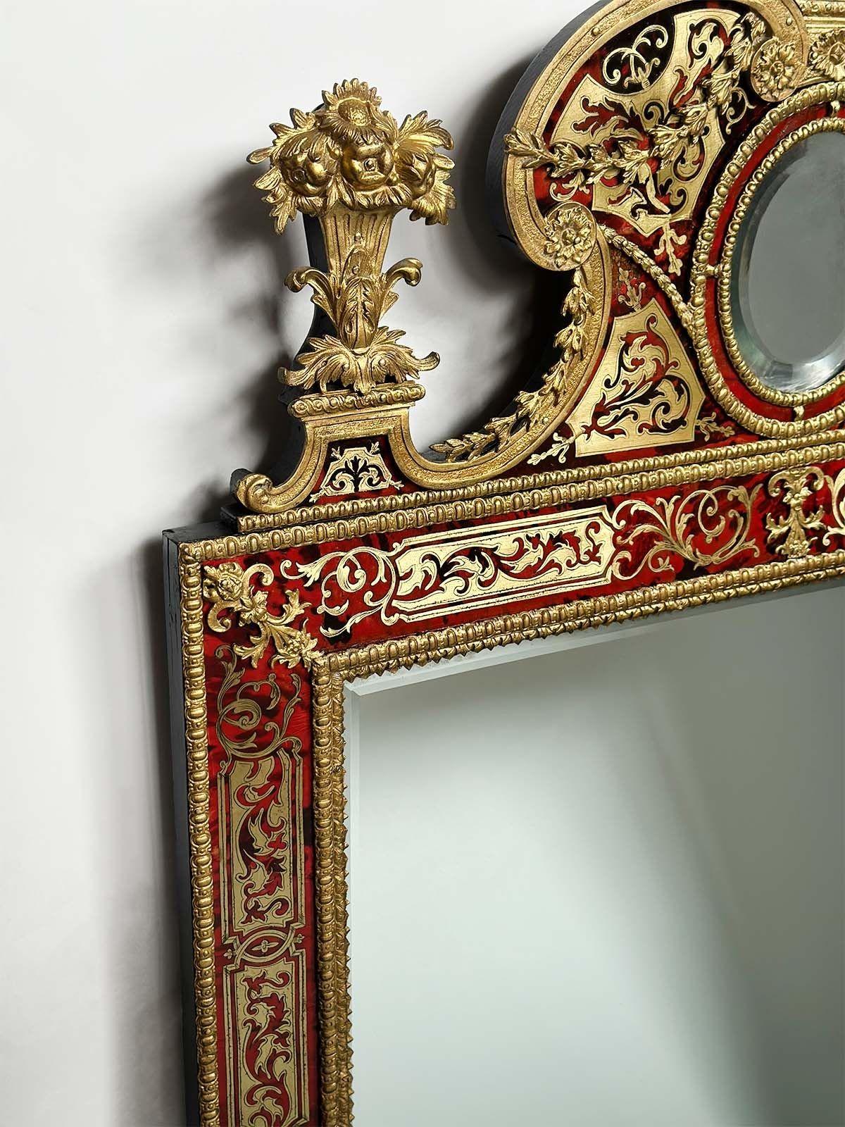 Fantastic mirror with beautiful boulle brass inlay accents and floral urn finials on top. It also consists of a center beveled glass oval mirror on top and lower rectangular beveled glass mirror. 
Made in France, 19th Century.
Dimensions:
51