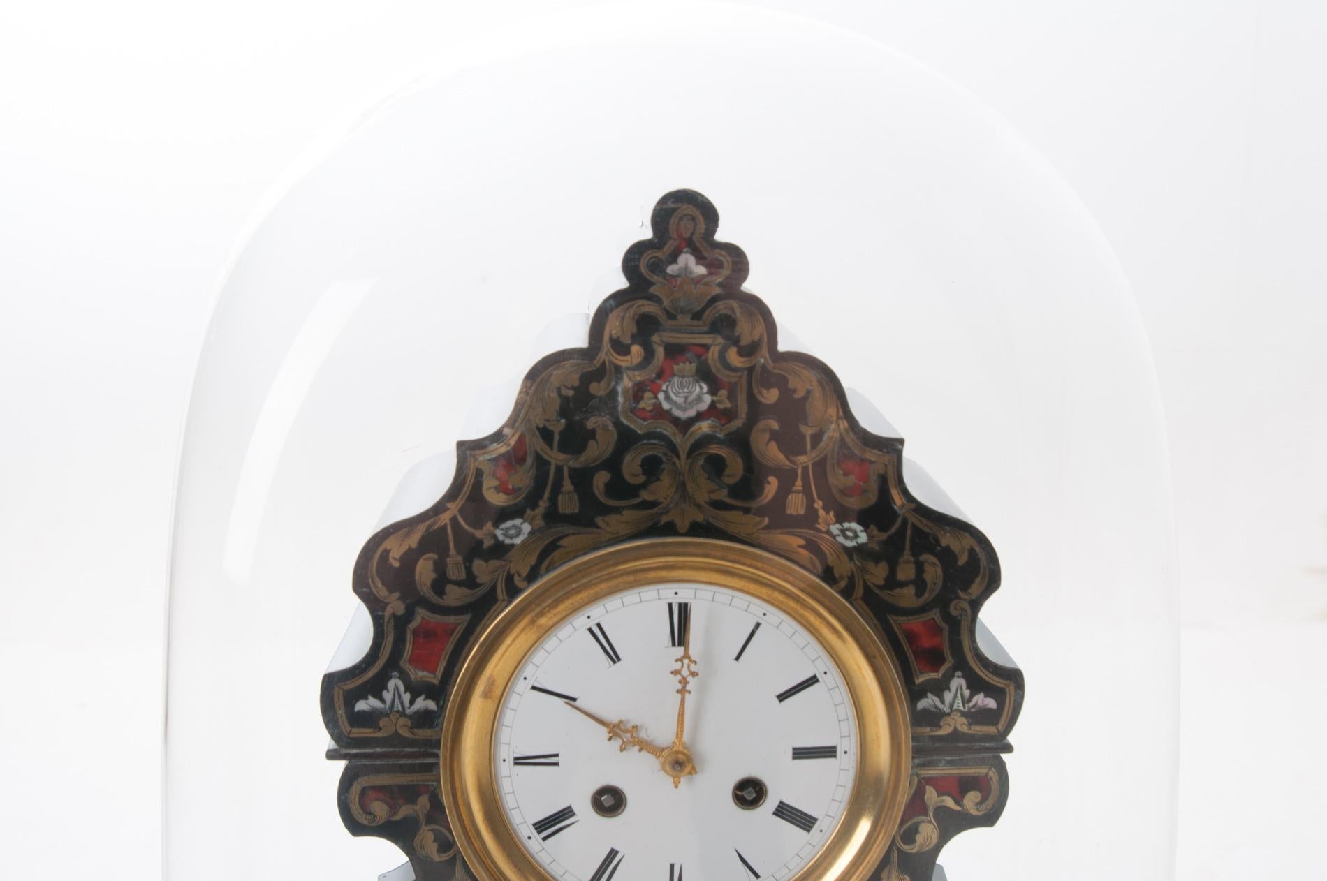 An absolutely stunning antique French boulle-work table clock on a domed Stand, circa 1840s. In the manner of André Charles Boulle, it is ebonized and inlaid with mother of pearl, etched-brass and tortoiseshell under a hand-rolled glass dome. This