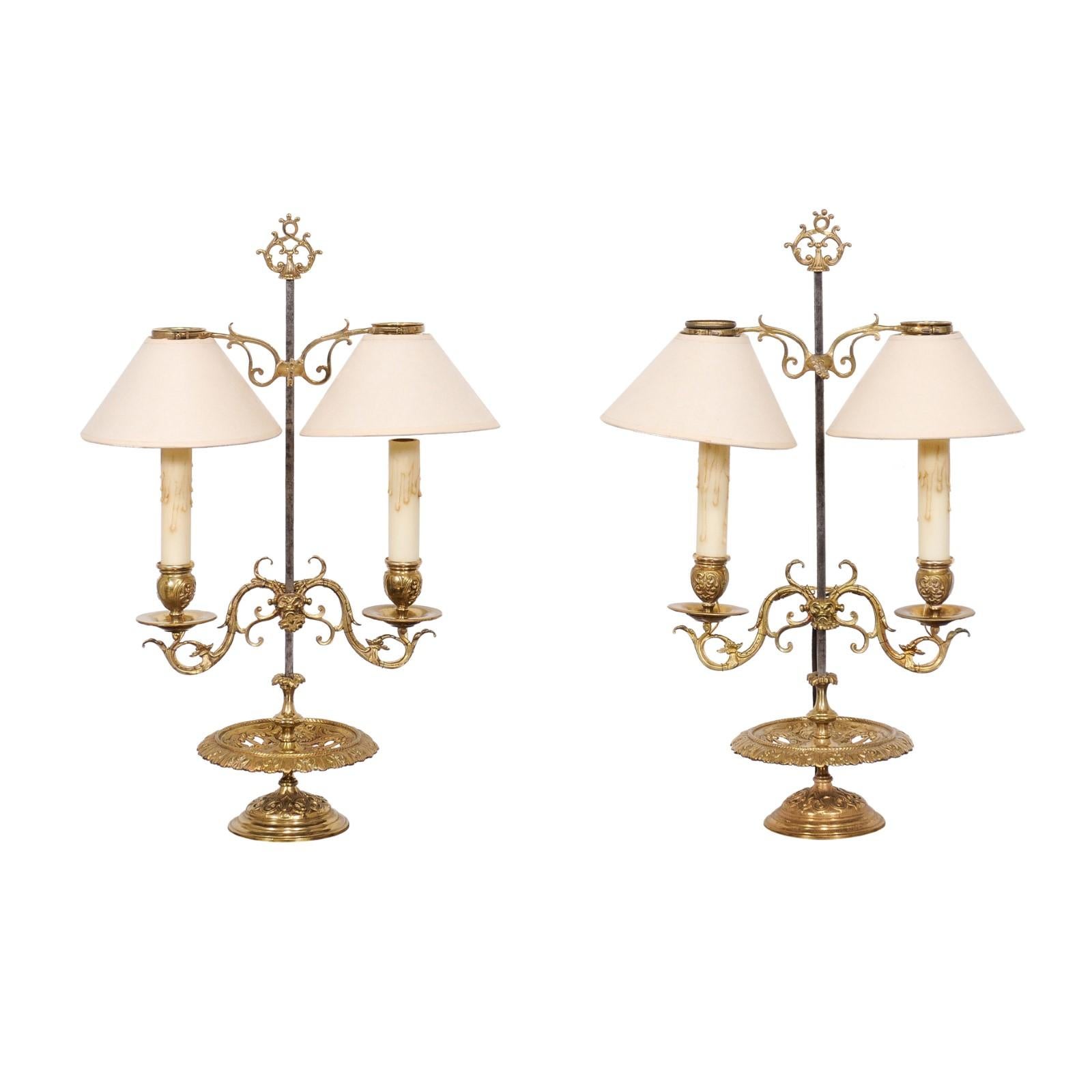 A pair of French brass candlestick table lamps from the 19th century with two scrolling arms each, professionally rewired for the USA. Introduce a touch of French romanticism into your home with these stately 19th-century brass candlestick table