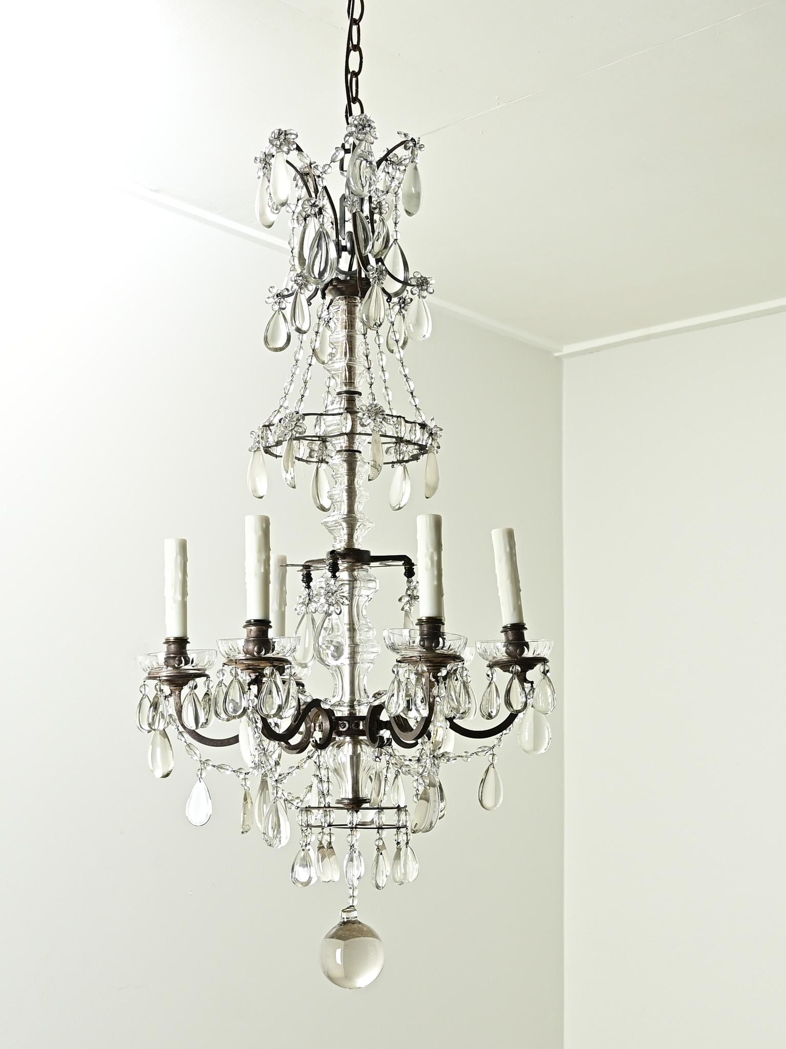 An impressive French six light brass and crystal chandelier from the 1800’s. This chandelier has a brass frame with cut crystal drops and six curved chandelier arms with faux wax candle covers. You’ll find playful patterns of cut crystal drop, swaps