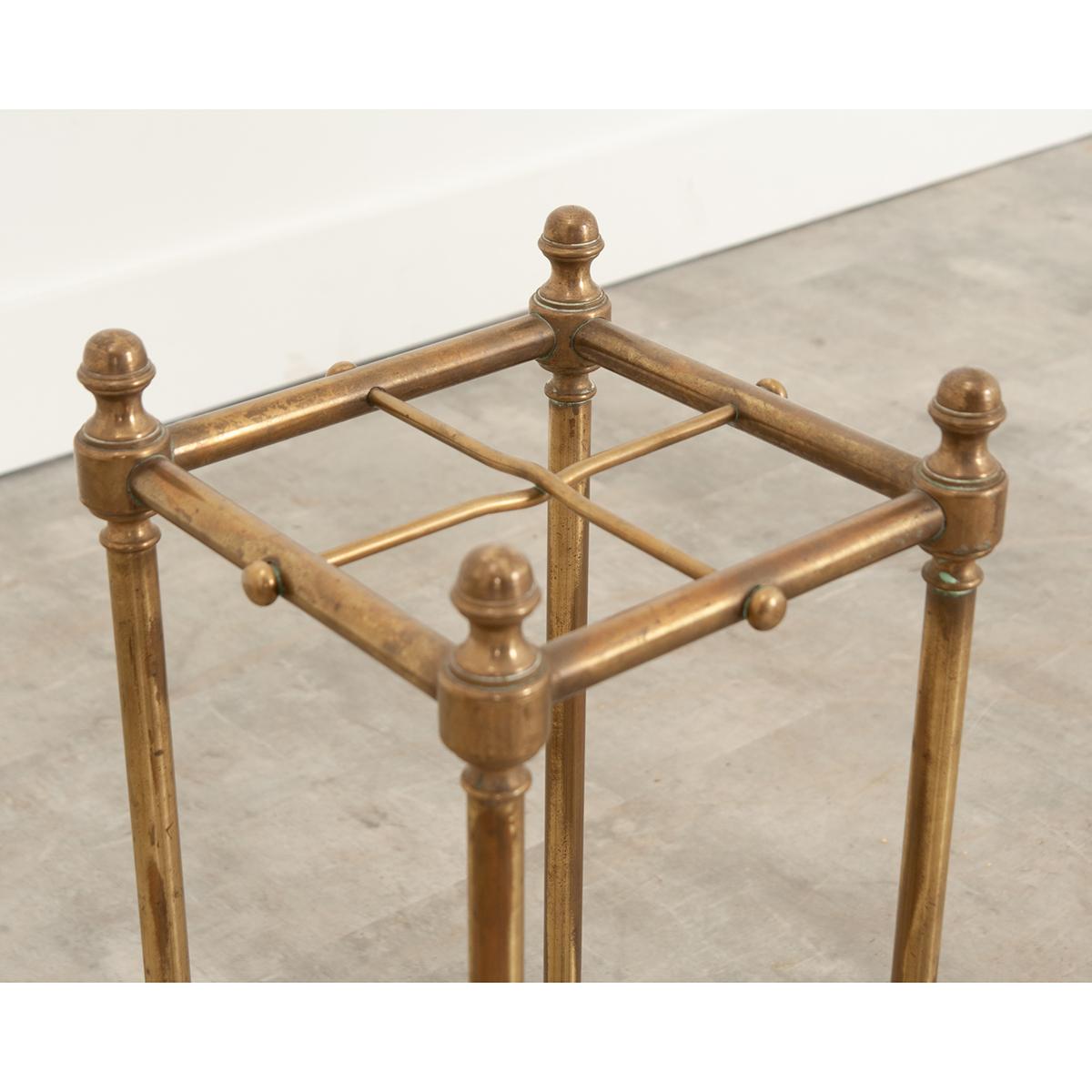 After trekking through the elements, leave your umbrella by the door in this polished brass umbrella stand made in France during the 19th century. The antique has spaces for up to four or more umbrellas or canes. The upright supports are topped with