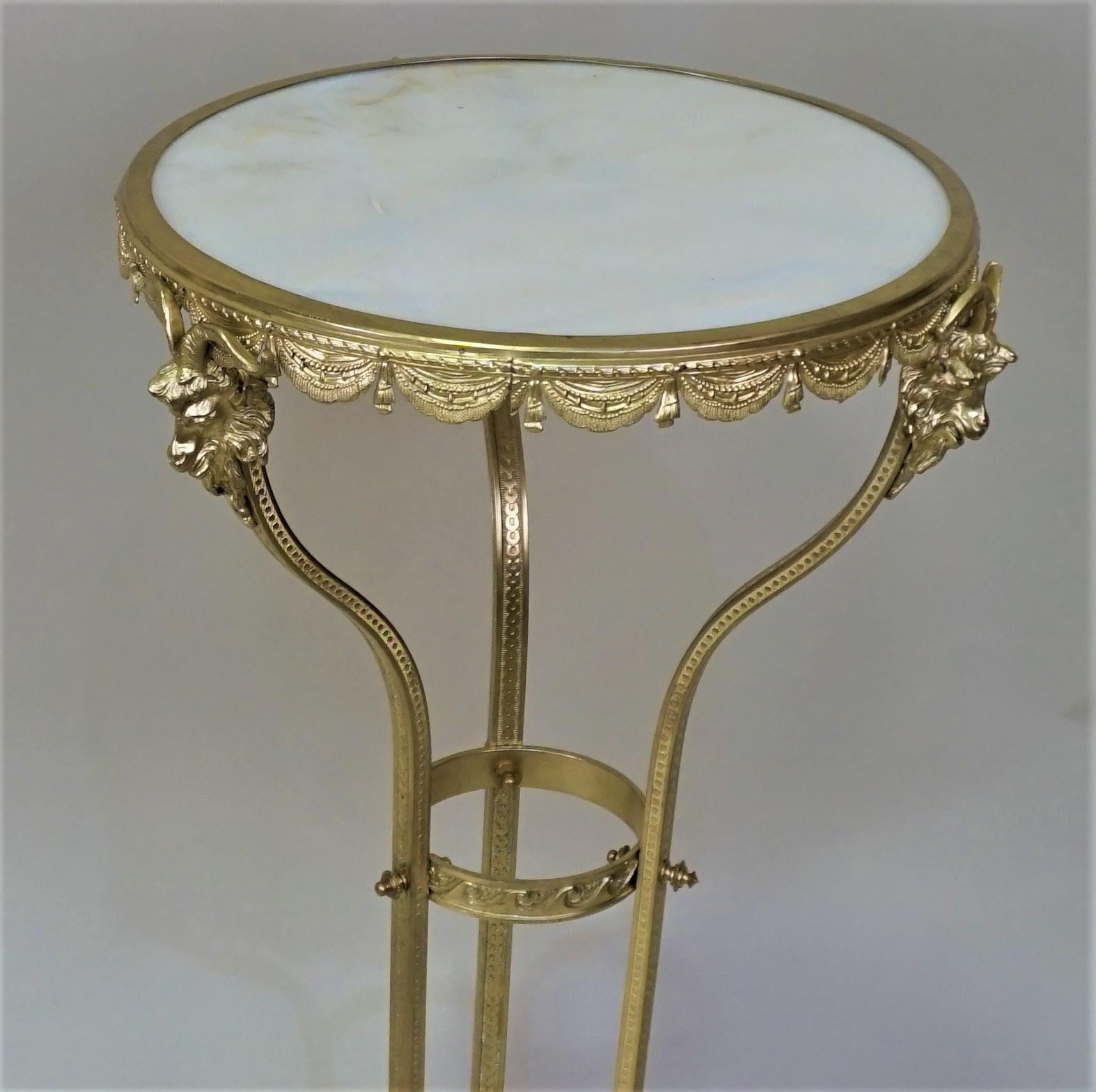 Table/support rond en onyx du XIXe siècle, en bronze, avec trois têtes de bélier retenant le plateau en onyx.