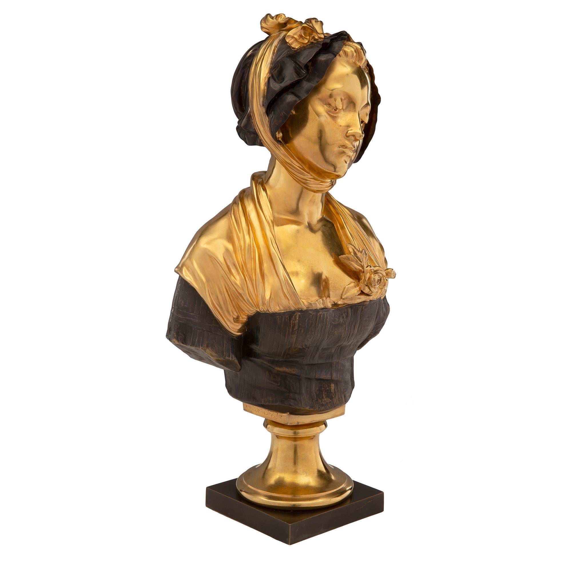 A charming French mid 19th century patinated bronze and ormolu bust of a young lady, signed by Elie-Joseph Laurent. The bust is raised by a square patinated bronze pedestal below a circular ormolu socle. The young lady is wearing a striped blouse