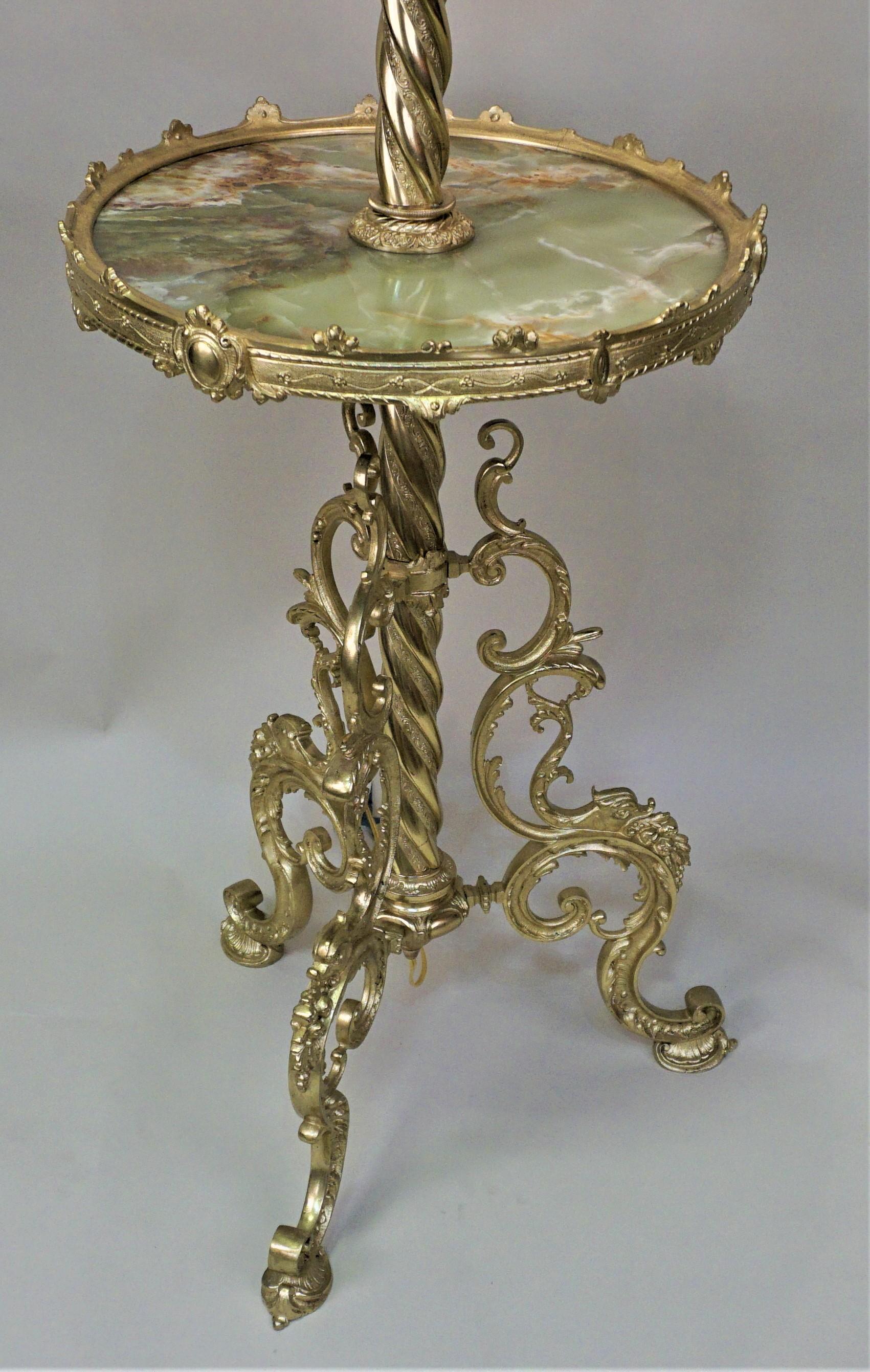 Elegant electrified 19th century bronze oil floor lamp with green onyx table.
Fitter with hand pleat silk lampshade.