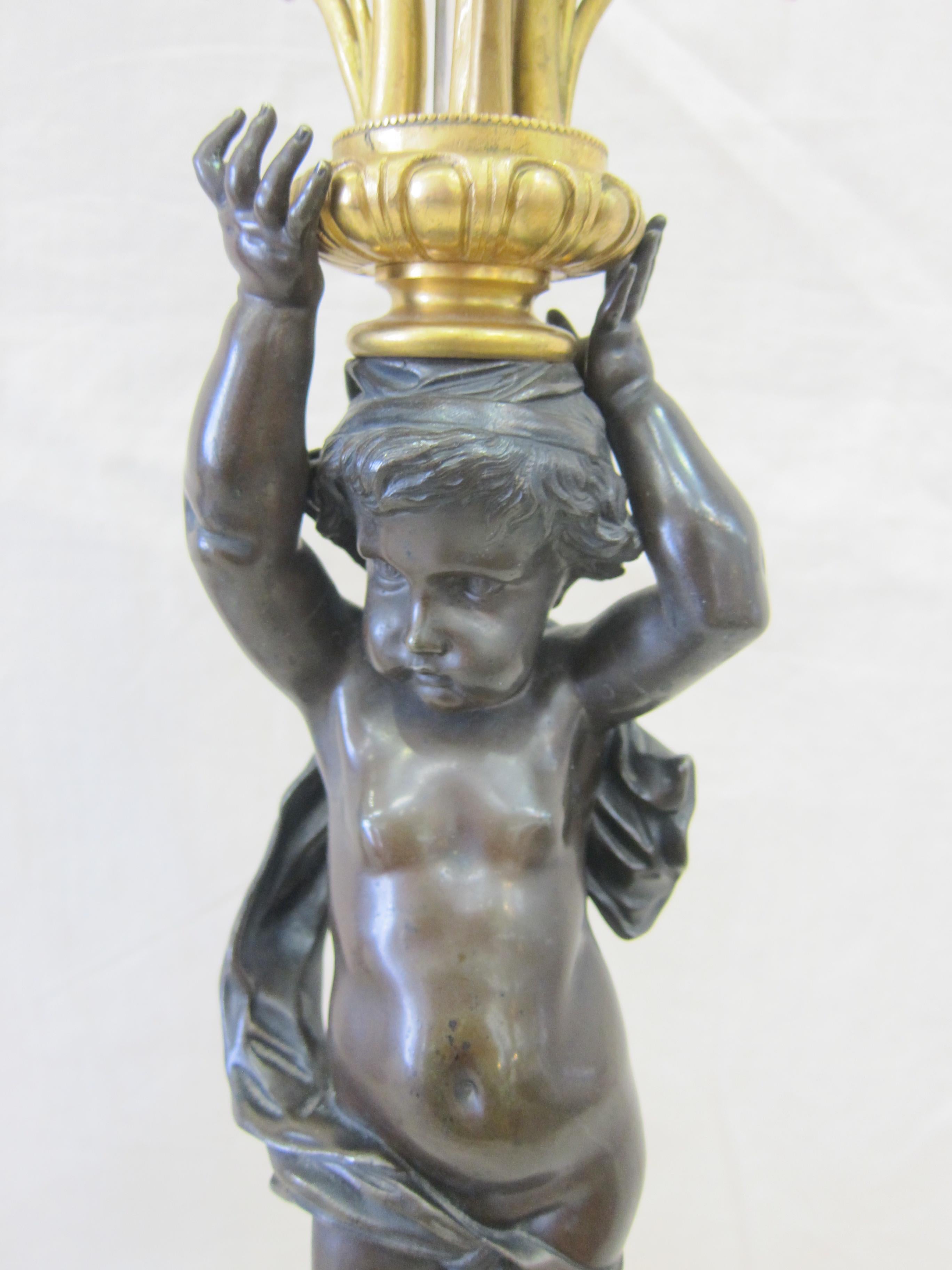 Espectacular pareja de lámparas candelabro Putti de bronce dorado francesas del siglo XIX.  Pareja Neoclásica de Lámparas Candelabro Putti Francesas de Bronce Dorado.  Bases de zócalo de mármol originales.  Un par verdadero que tiene una imagen del