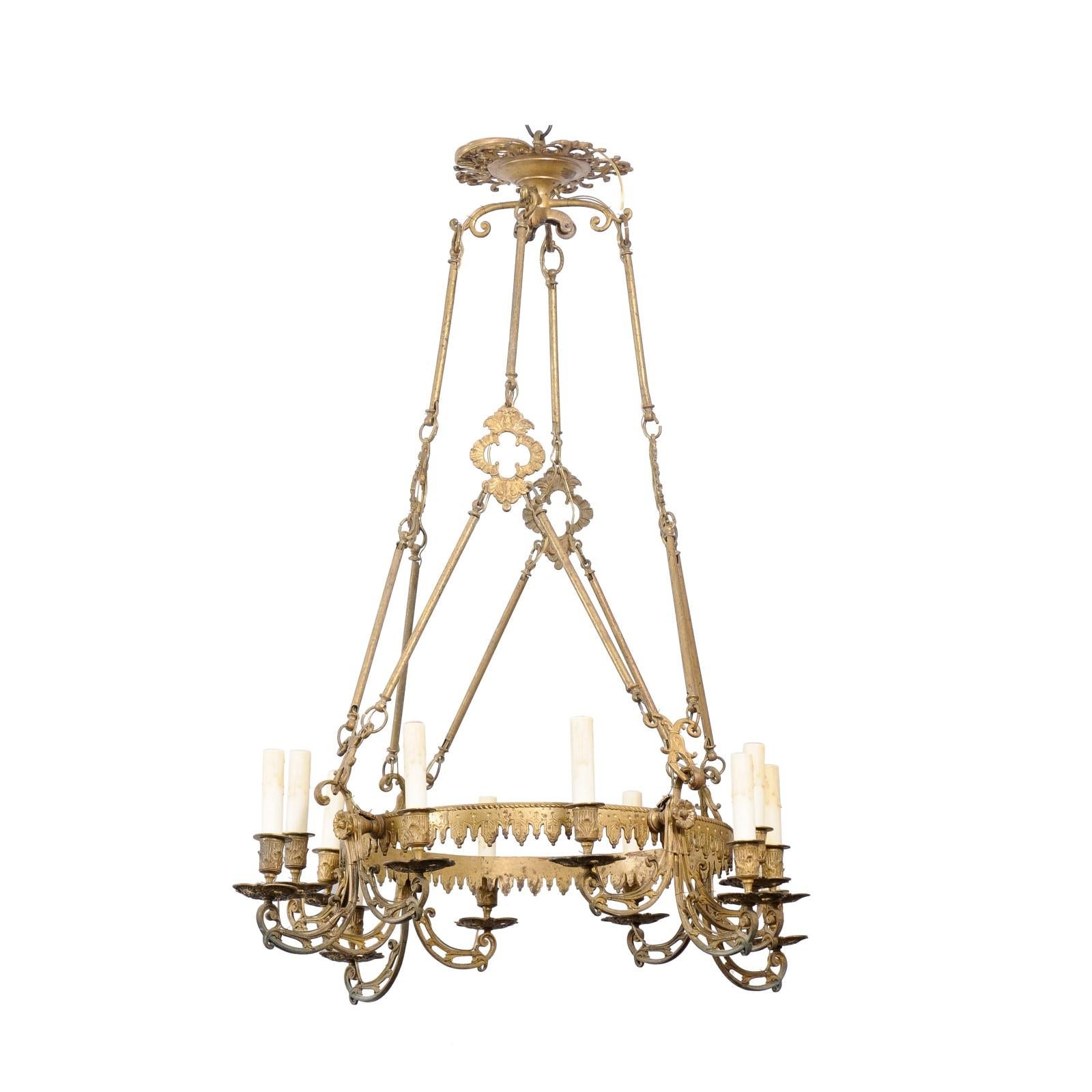 A French twelve light bronze ring chandelier from the 19th century with scrolling arms, foliage and floral motifs and profile links. This exquisite French twelve-light bronze ring chandelier from the 19th century stands as a timeless beacon of
