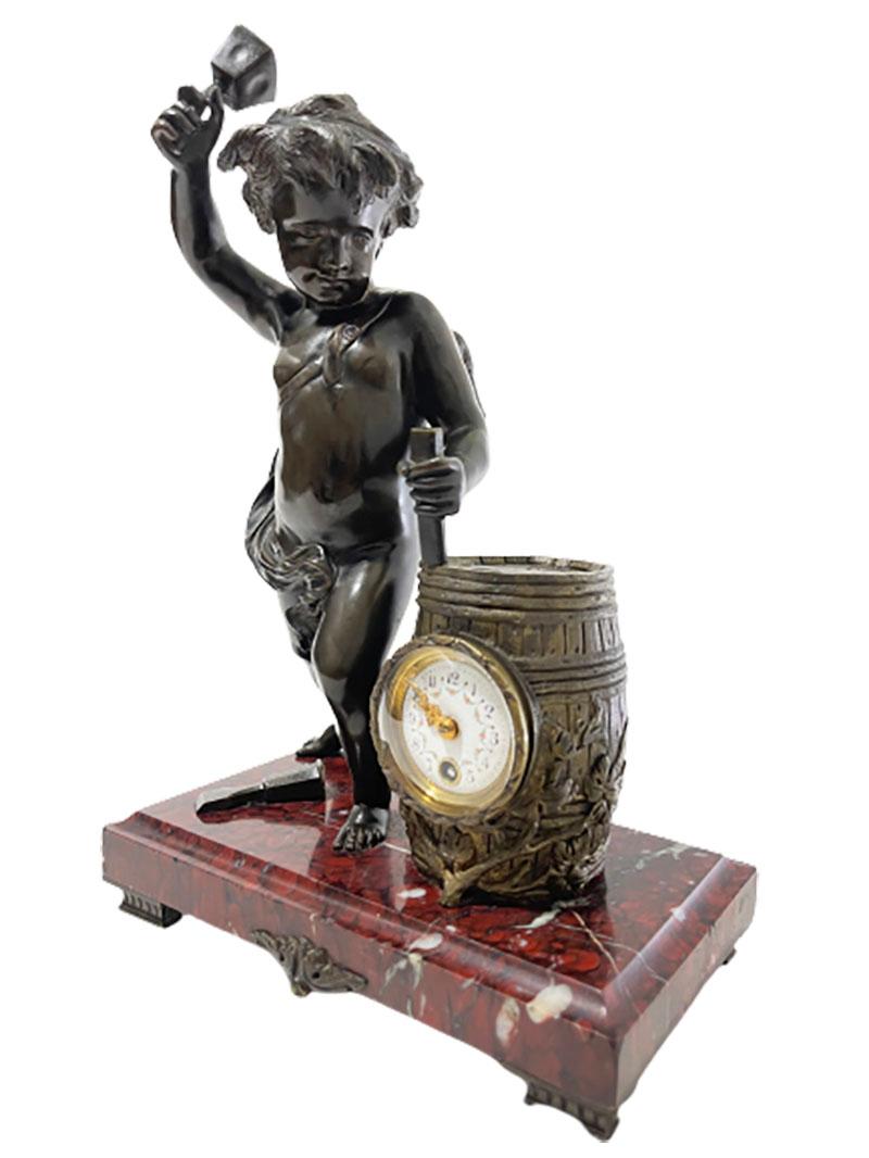 French 19th century Bronze with marble base mantel clock, pendule

A 19th century French mantel clock with bronze putti on a brown, red, white and black marble base, with an ornament in the middle, raised on 4 feet. The putti beats the wine barrel