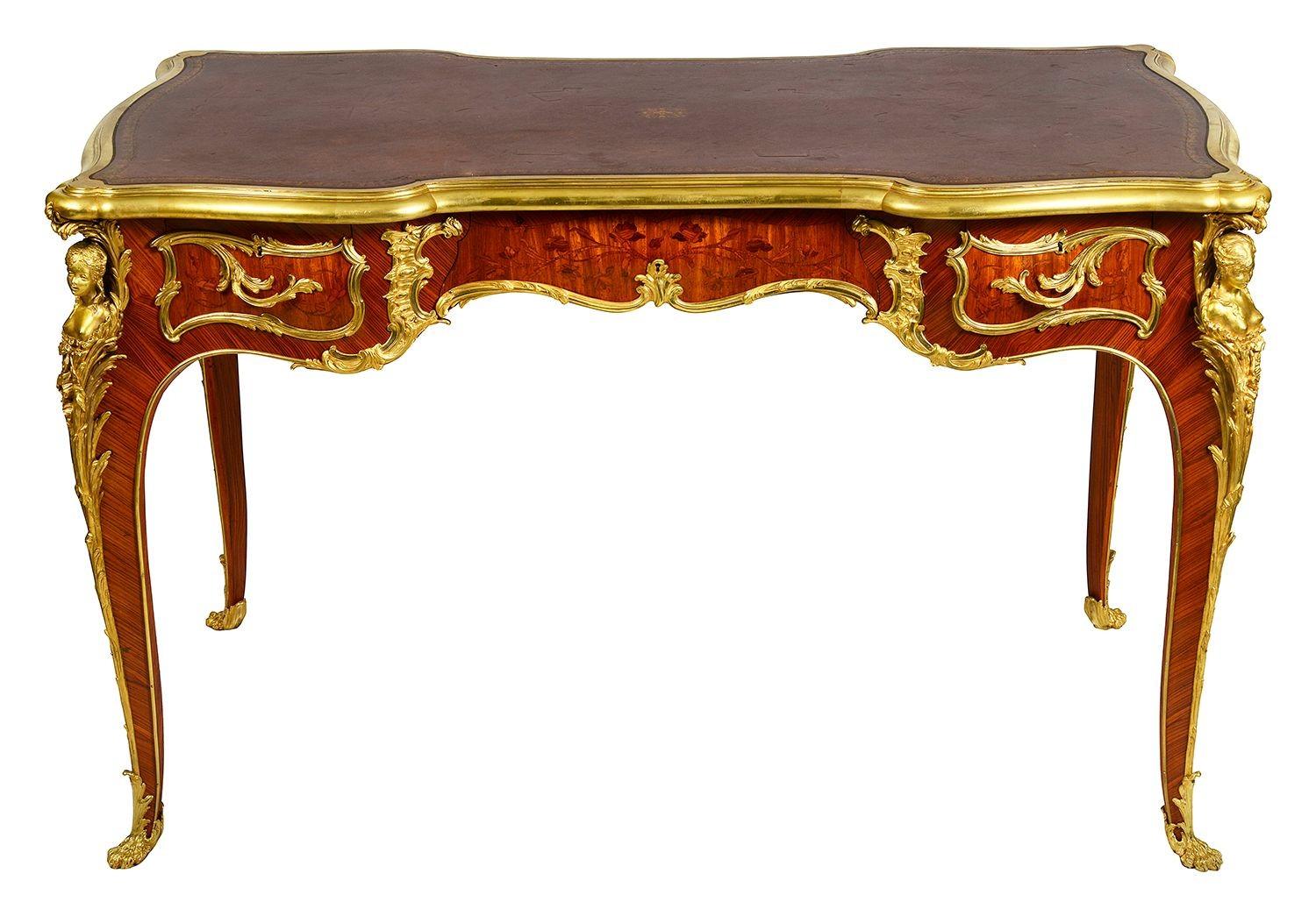 This exquisite Louis XVI style bureau plat, crafted in the 19th century by Zweiner, showcases the elegance of French design. Featuring a luxurious inset leather top, the piece is adorned with intricate marquetry inlay around the frieze. Gilded